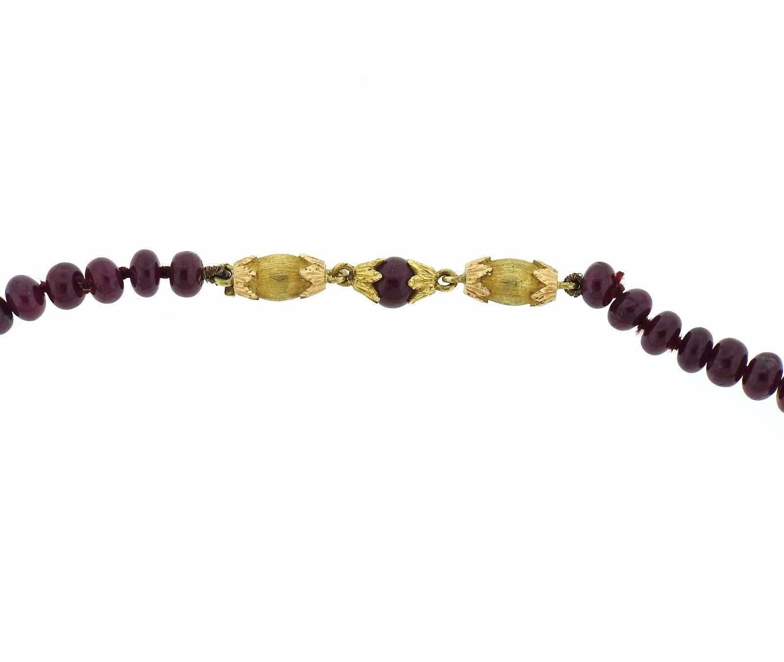 An 18k yellow gold necklace set with 5mm - 5.5mm ruby beads.  The necklace is 19 3/8