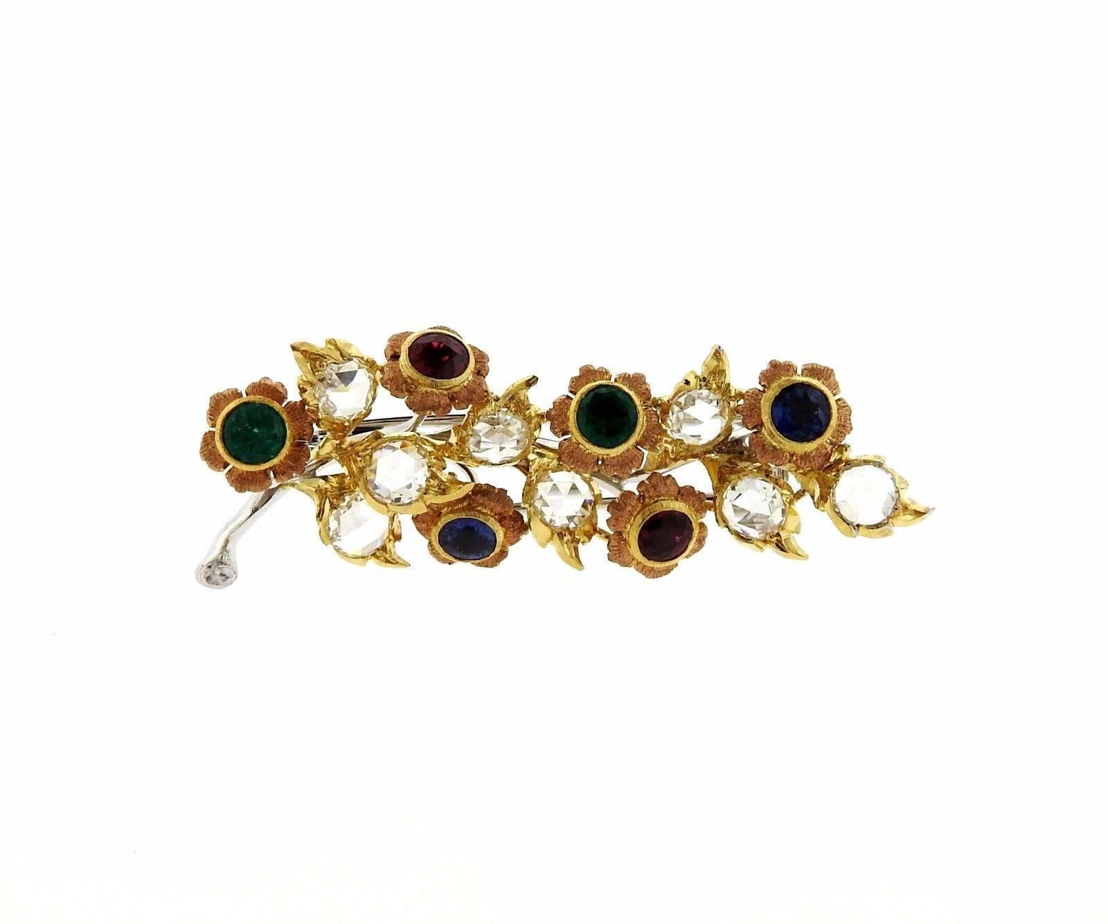 An 18k yellow and white gold brooch set with rose cut diamonds, sapphires, rubies and emeralds.  The brooch measures 50mm x 18mm and weighs 9.9 grams. Marked: Gianmaria Buccellati Italy 18k H5530.  Retail is $29,440. Comes with Buccellati paperwork.