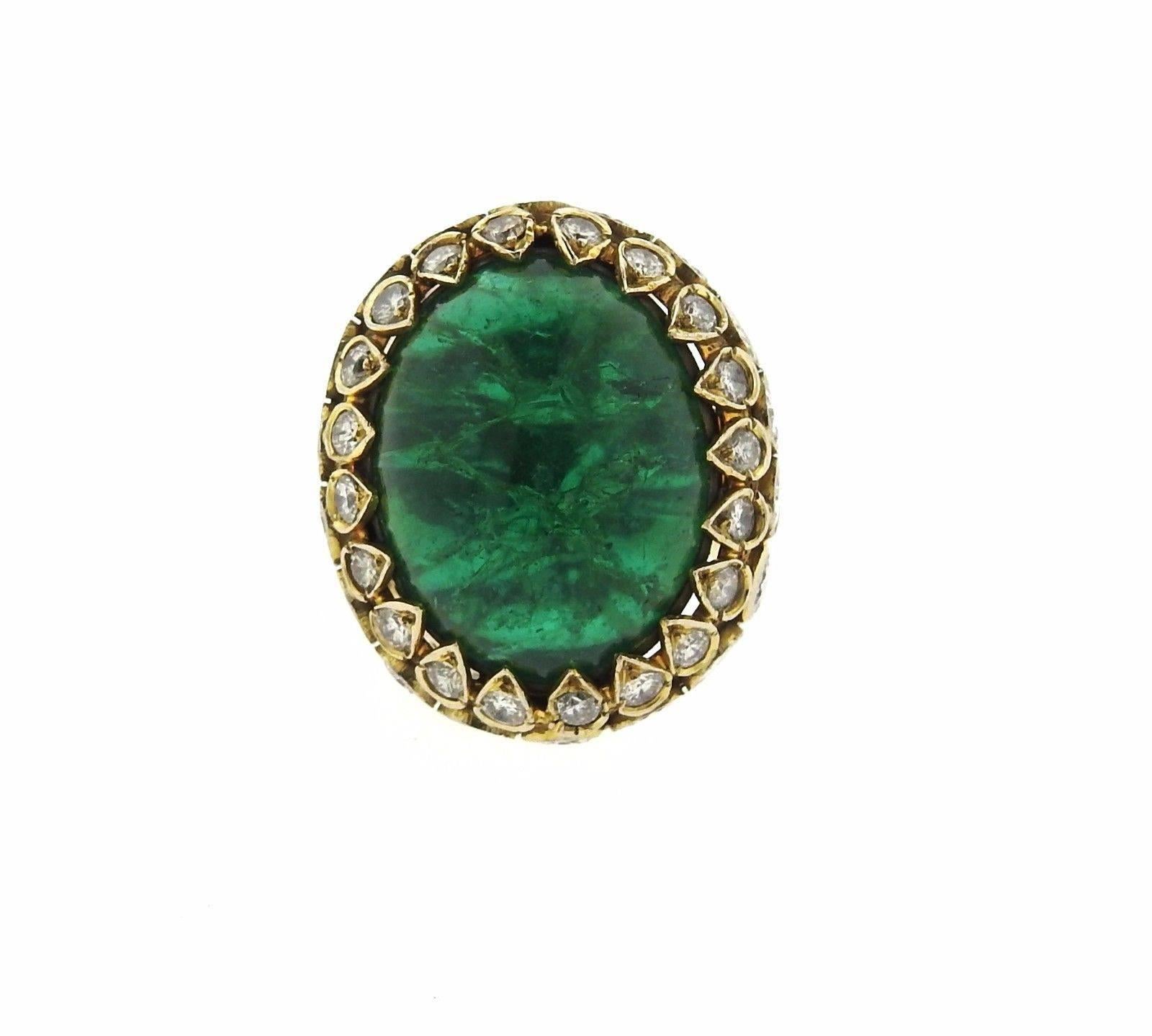 An 18k yellow gold ring set with an emerald cabochon weighing approximately 55 carats (21mm x 18mm x 18.5mm) and approximately 5.70ctw of H/VS-SI diamonds. The ring is a size 6 1/4 and the top of the ring is 30mm x 25mm, sits approximately 17mm from