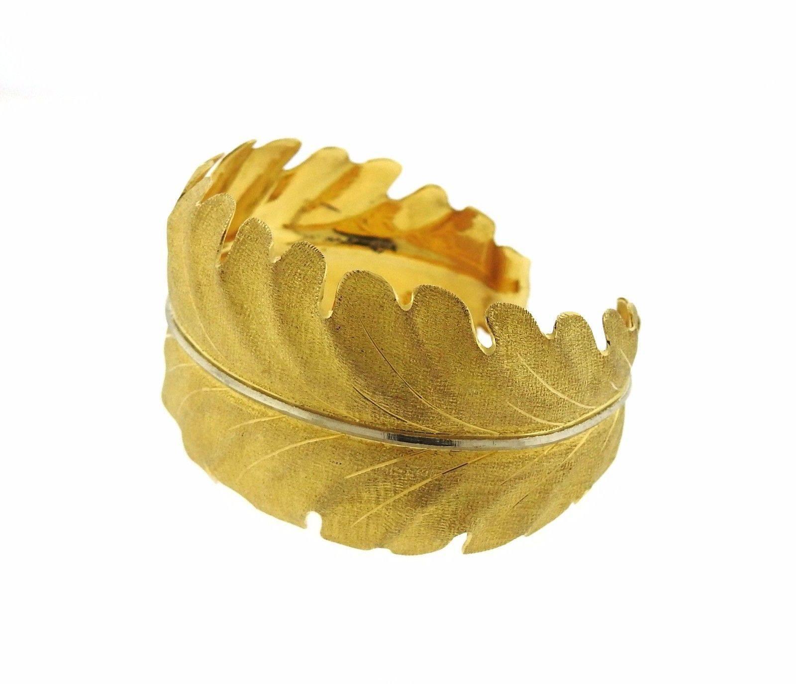 An 18k yellow and white gold leaf motif cuff bracelet.  The bracelet will fit up to a 6