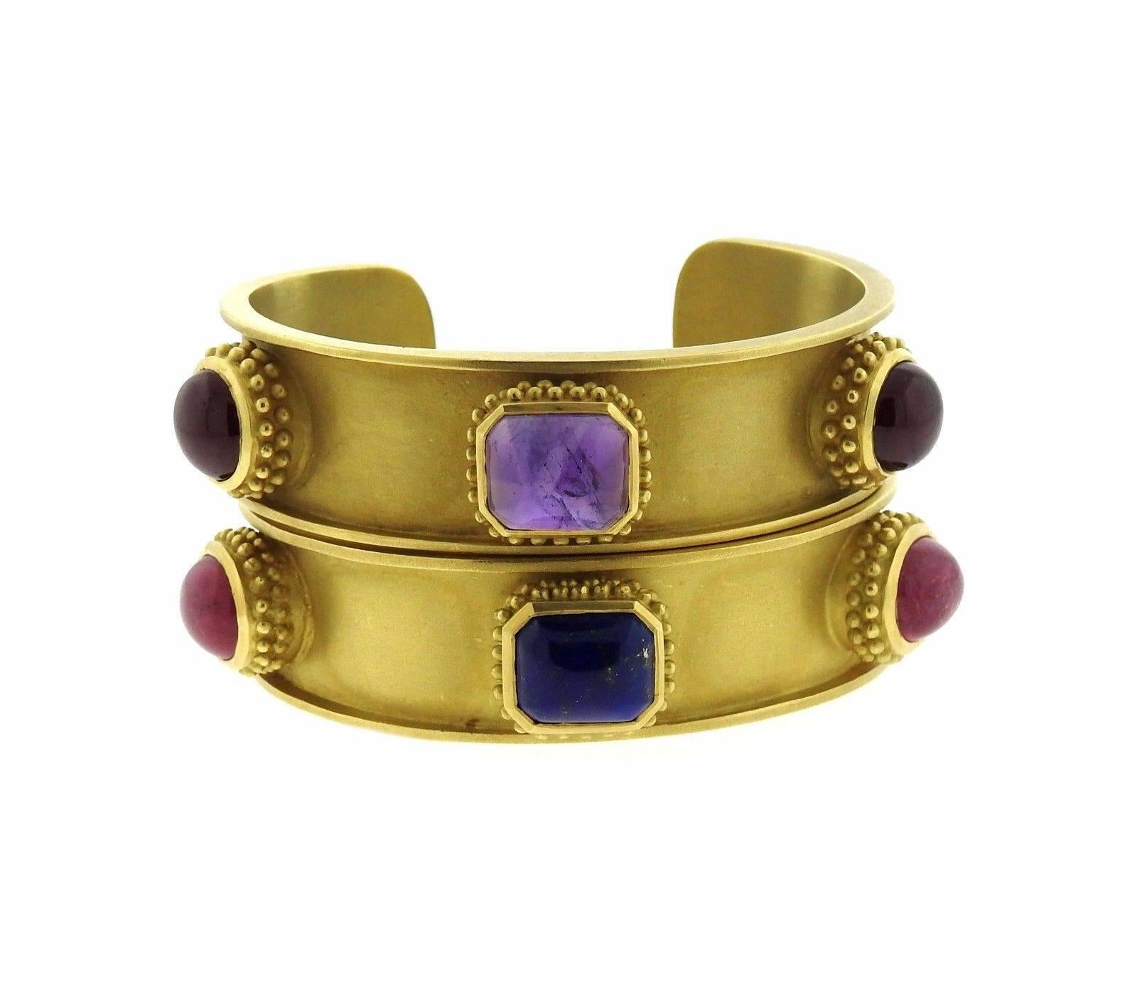 A pair of 18k gold cuff bracelets set with tourmaline, lapis and amethyst.  The bracelets fit a 6.5