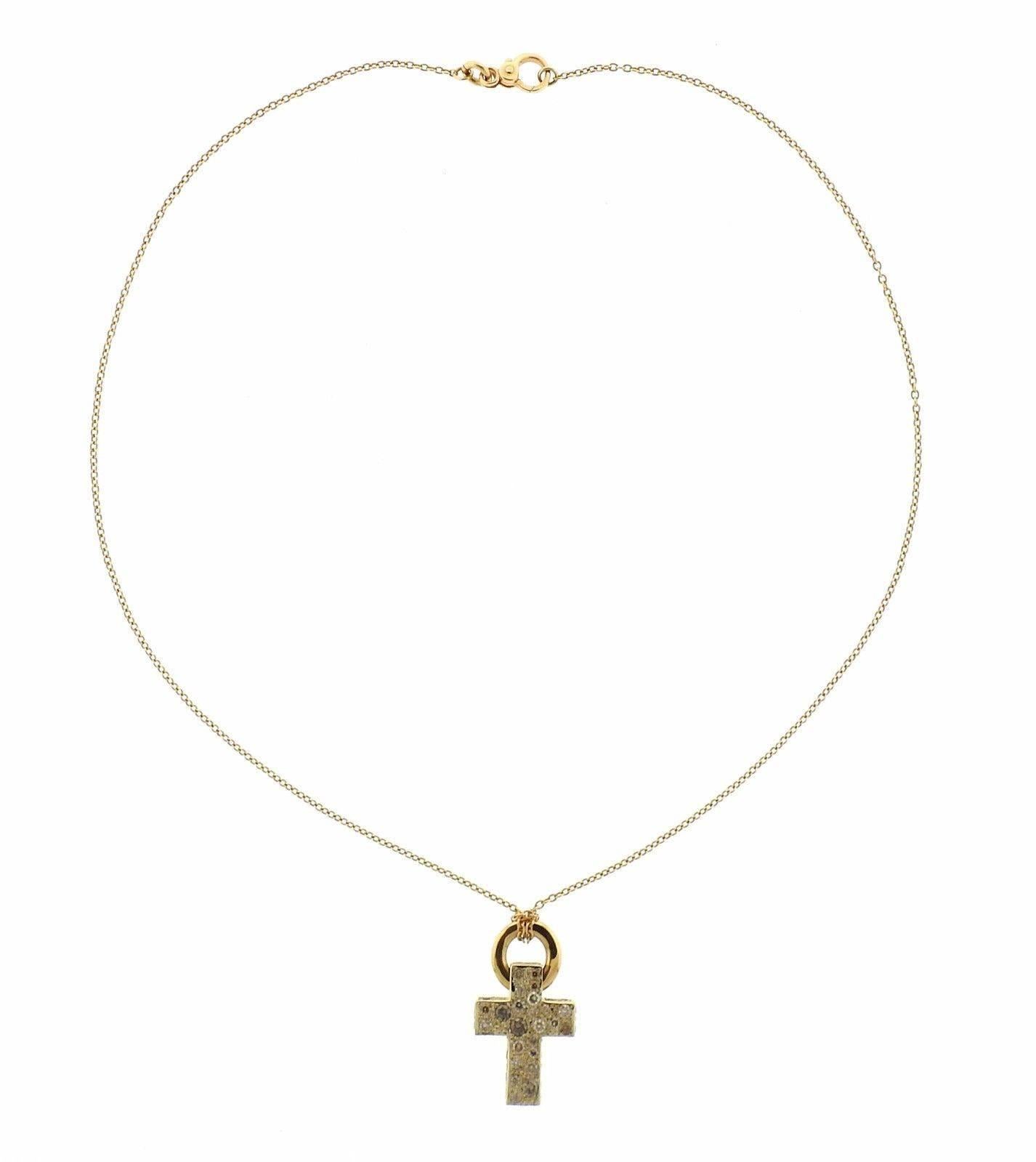 An 18k yellow gold cross pendant necklace set with approximately 1 carat of fancy color diamonds.  The necklace is 16