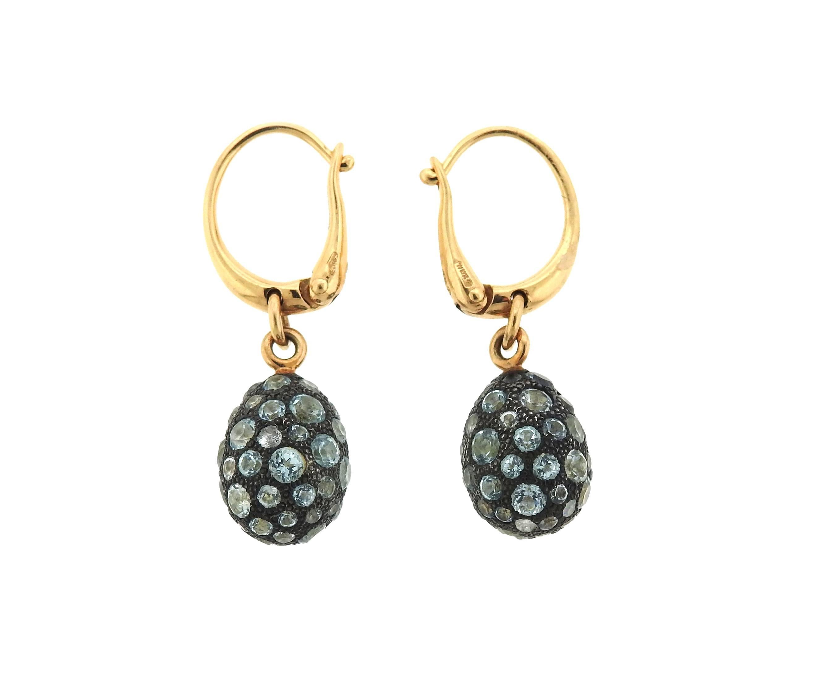 A pair of 18k gold and burnished silver drop earrings, crafted by Pomellato for Tabou collection, set with blue topaz. Earrings are 30mm long x 9mm wide. Weight - 9.8 grams. Retail for $5150 