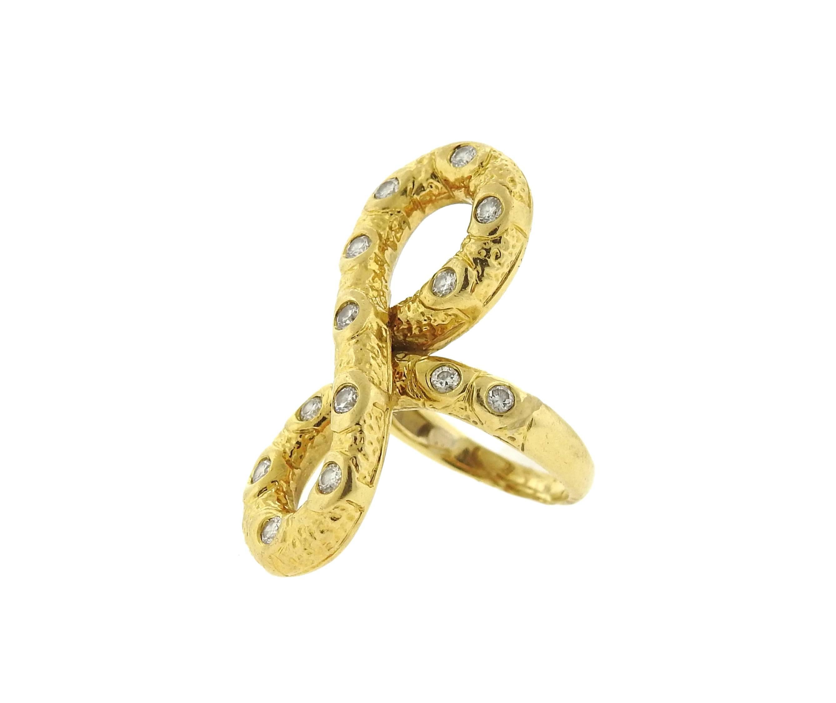 An 18k yellow gold infinity figure eight sign ring, crafted by Van Cleef & Arpels, decorated with approx. 0.45ctw in diamonds.  ring size - 5, ring top is 34mm x 13mm. Marked: VCA. Weight of the piece - 11.4 grams 