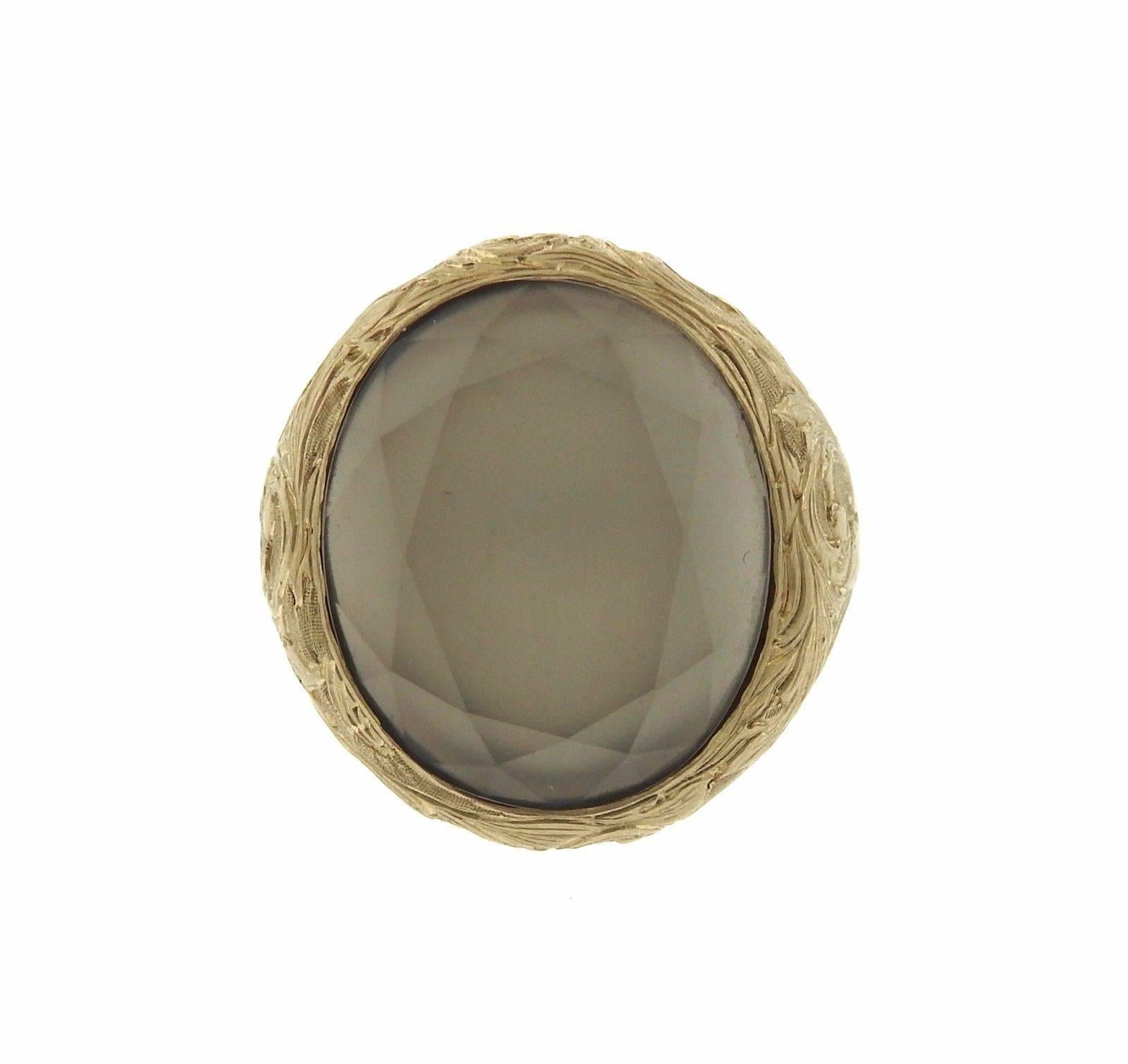 A 19k gold ring set with a faceted gray moonstone.  The ring is a size 5.75, top measures 22.5mm x 21.5mm.  The weight of the ring is 19.3 grams.  Marked: Anaconda, Gold Marks.

Monica Rossi has been designing and creating Anaconda jewelry - a
