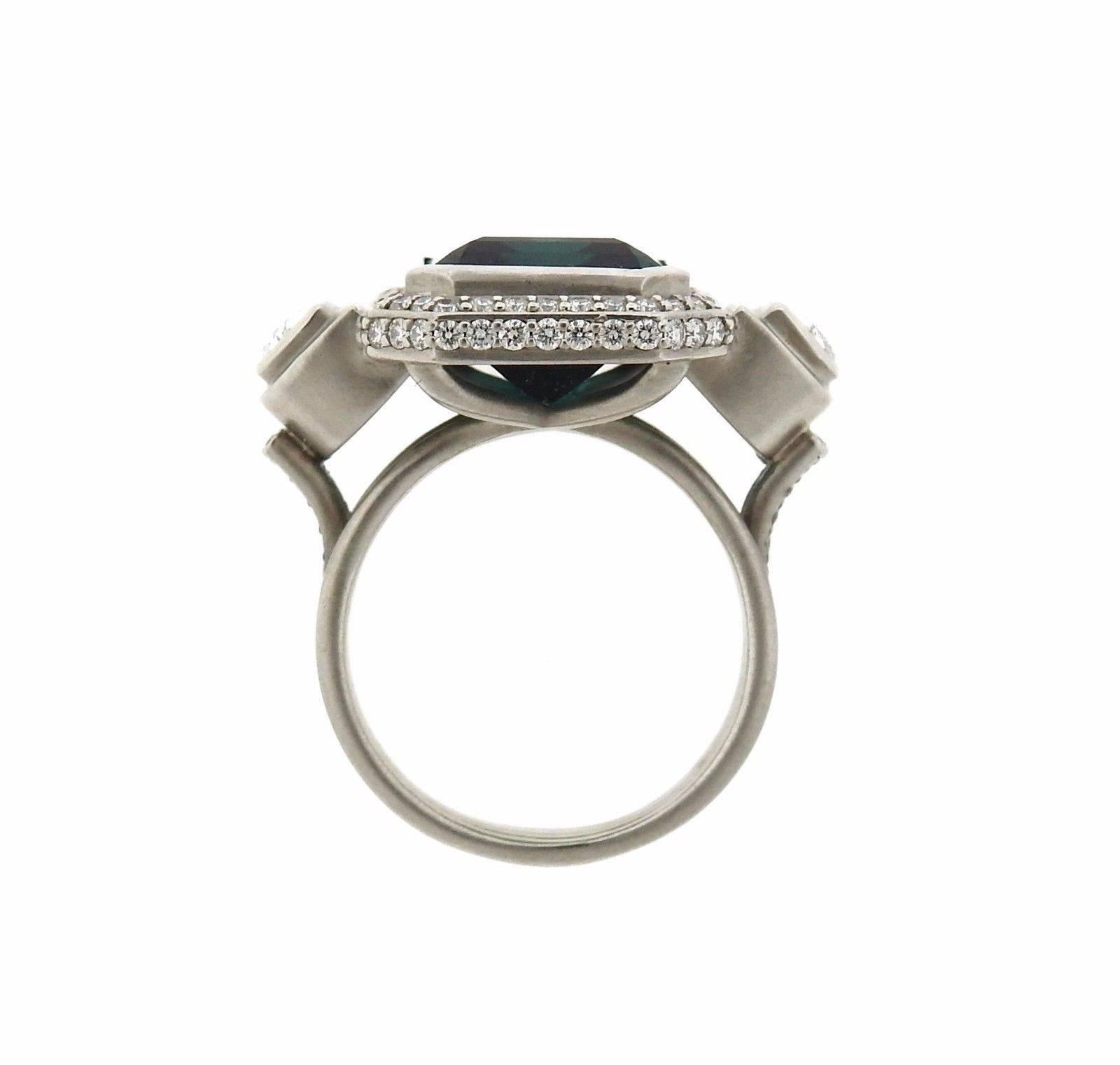 An 18k white gold ring set with a 10.80ct blue green Indicolite and approximately 1.65ctw of G/VS1 Diamonds.  The ring is a size 8. Ring top is 27mm x 19.5mm at widest point.  The weight of the ring is 16.9 grams.  Marked: 18K Sam Lehr.  Comes with