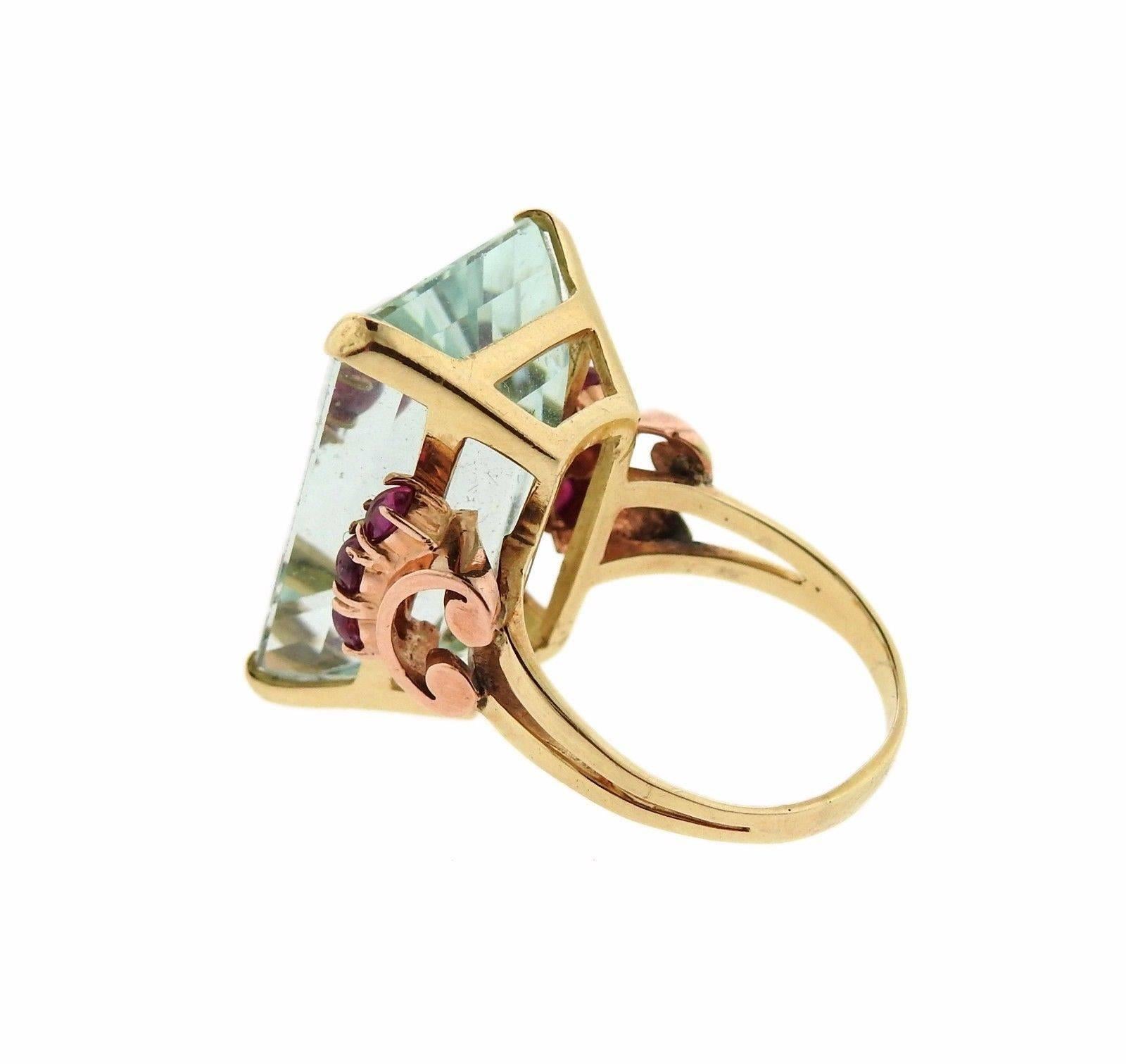 A retro 14k yellow and rose gold ring set with a 29.76ct aquamarine and ruby accents.  The ring is a size 8.5.  The weight of the ring is 13.2 grams. Marked: 14k.