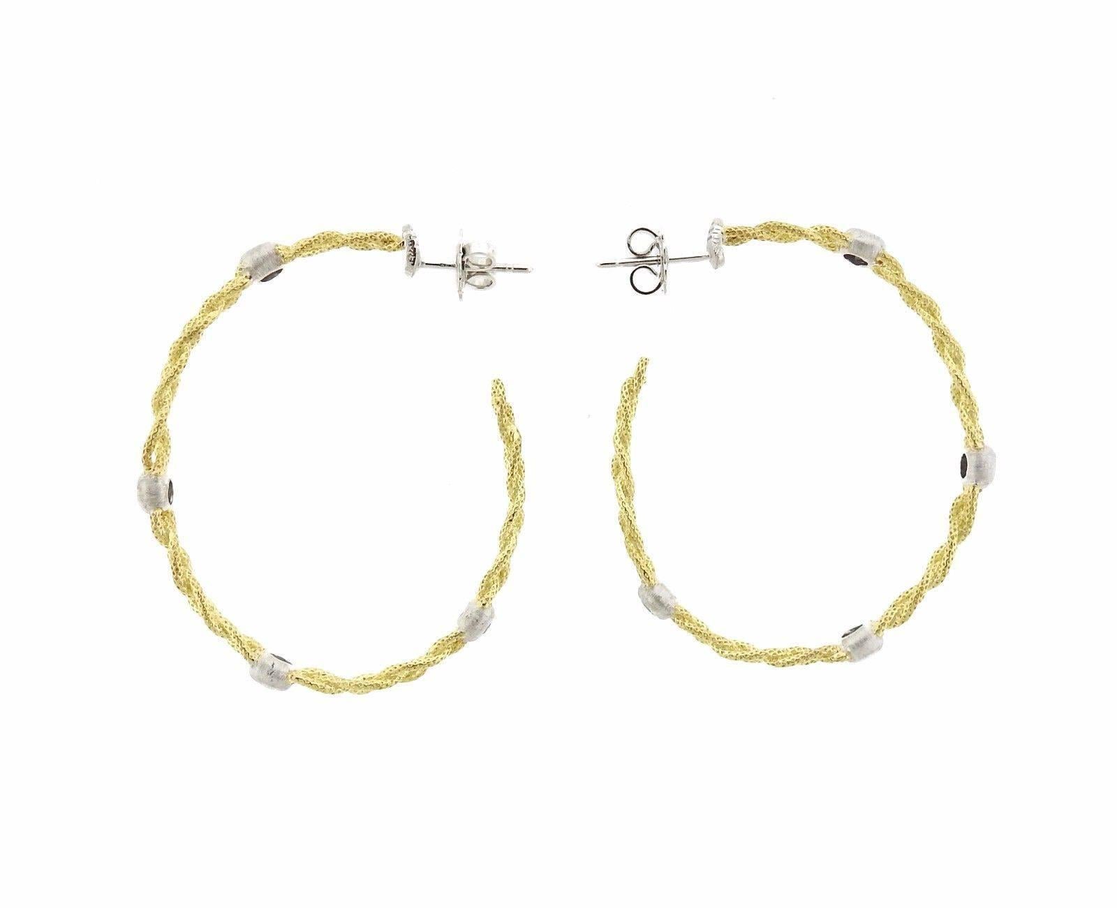 A pair of 18k yellow and white gold hoop earrings set with approximately 0.85ctw of H/VS diamonds.  The earrings measure 40mm in diameter and are 3mm wide.  The weight of the pair is 11.7 grams.  Marked: 18k,  Italy, Buccellati.