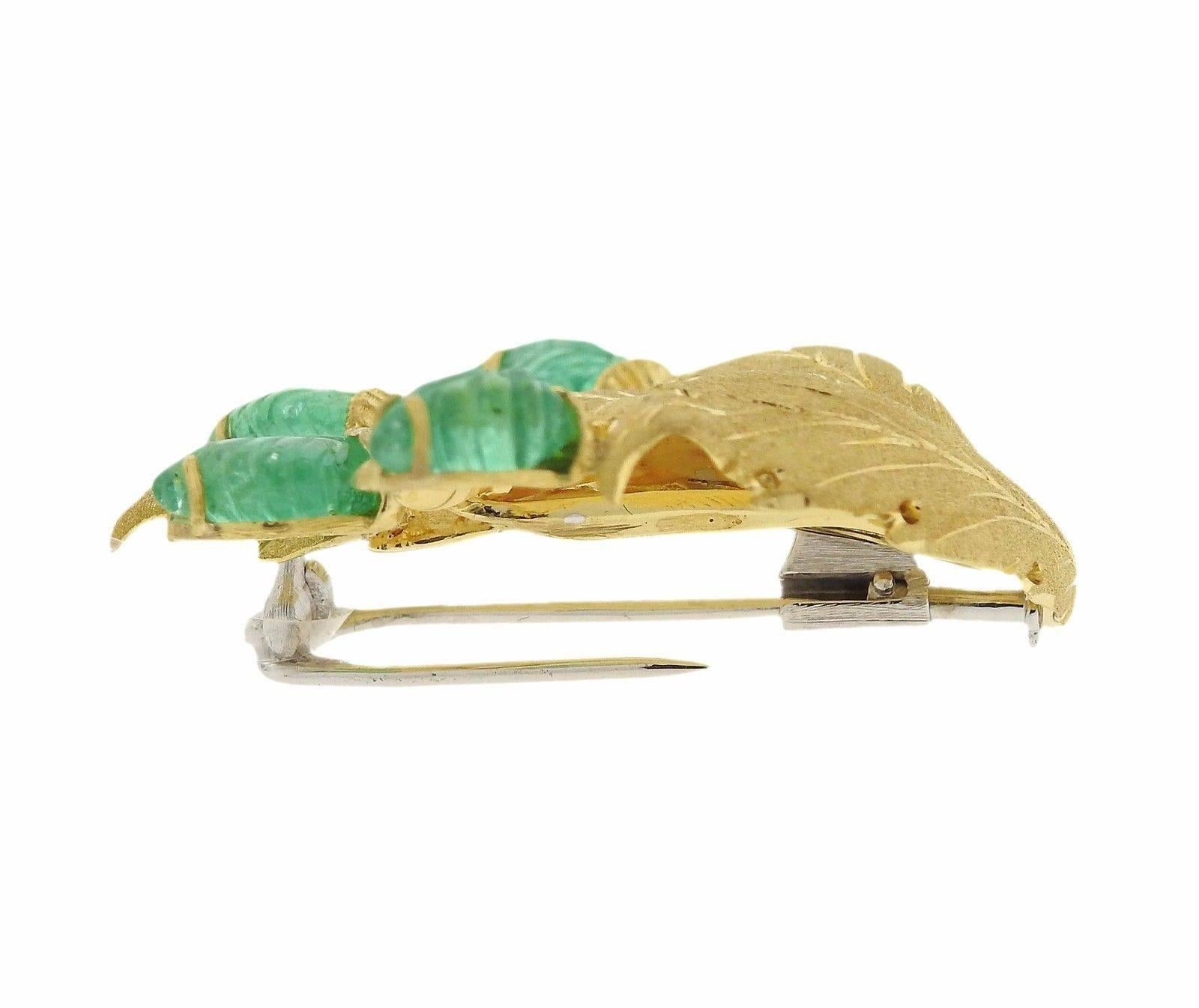 An 18k gold brooch set with carved emerald leaves.  The brooch measures 37mm x 38mm and weighs 10.1 grams.  Marked: 18K, Italy, Buccellati.  The brooch comes with a Buccellati box and papers.  The retail for this piece is $12340.