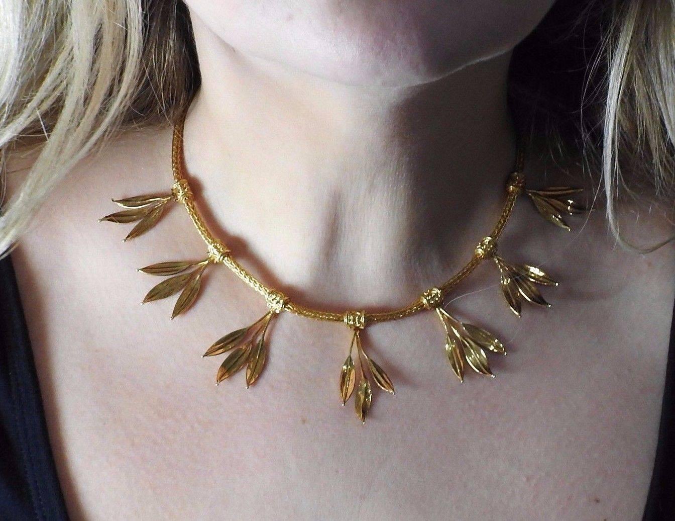An 18K yellow gold necklace with leaf motif stations.  The necklace is 16