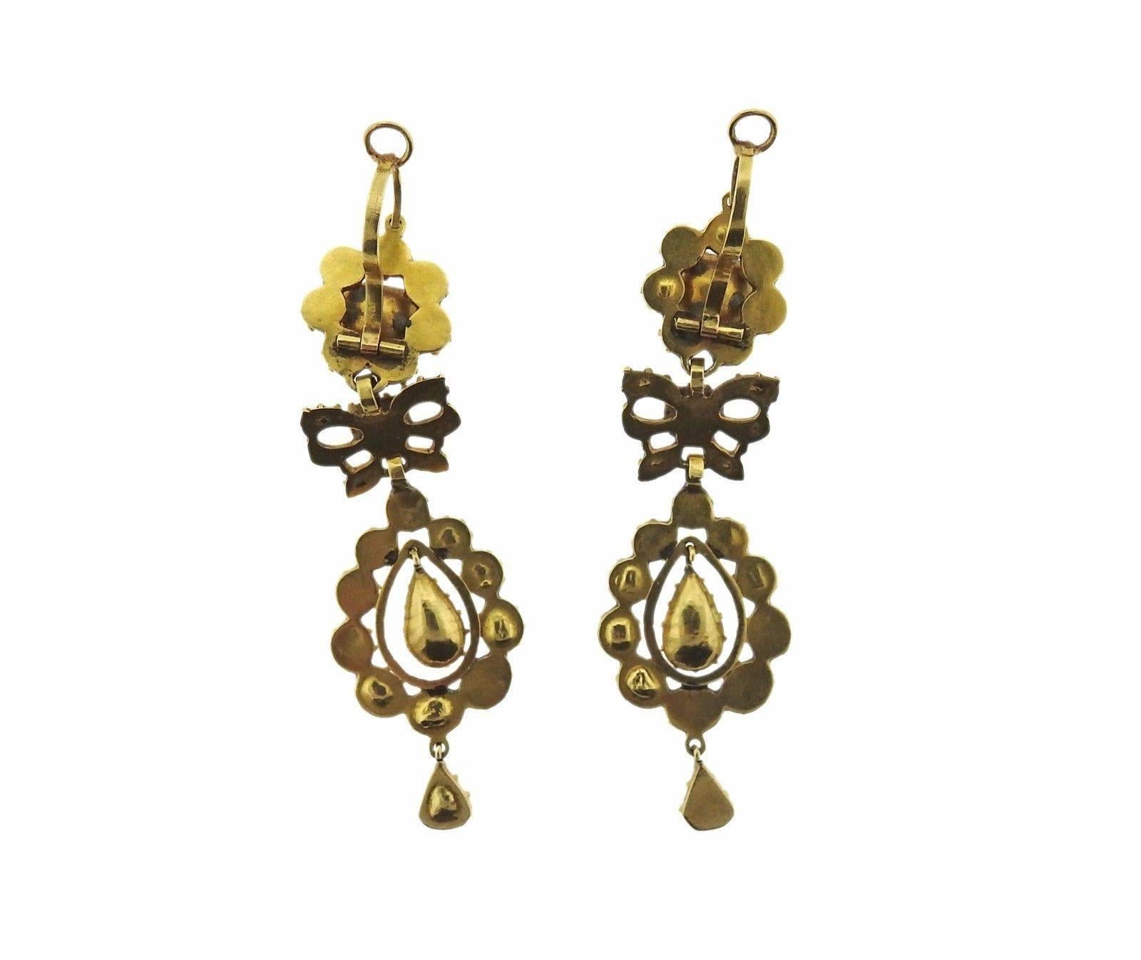 A pair of 14k gold earrings set with emeralds.  The earrings measure 70mm including the wire x 20mm.  The weight of the set is 16 grams.