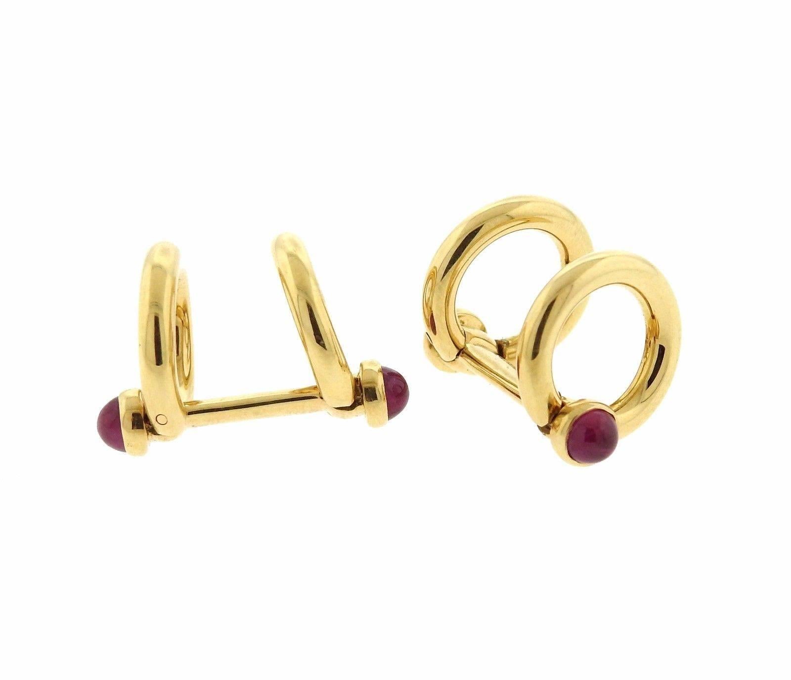 A pair of 18k gold cufflinks set with ruby cabochons.  Cufflink tops measure 13.7mm in diameter and weigh 13.9 grams.  Marked: Suna 18K 7447 8.