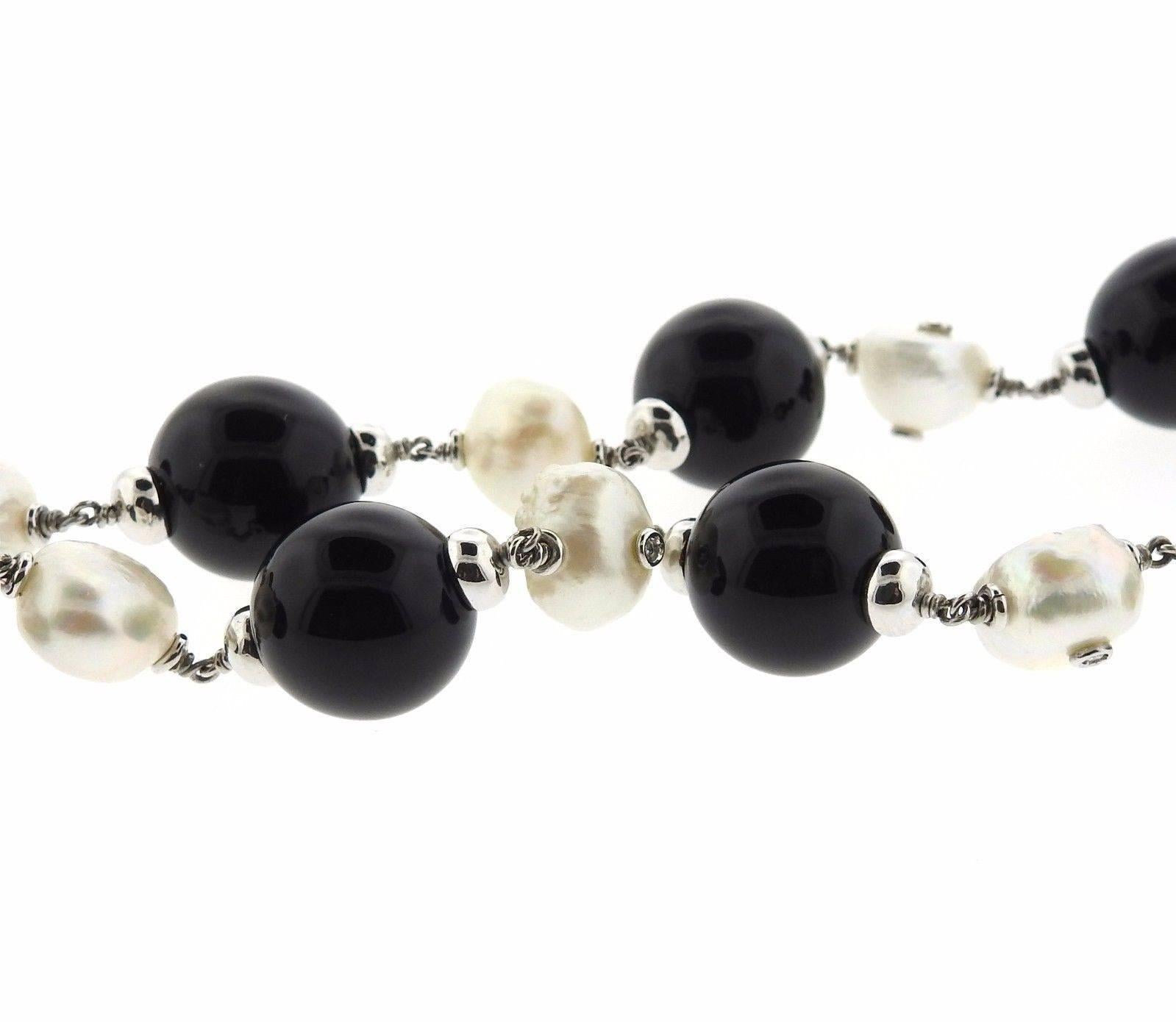 Lovely 18k gold necklace featuring onyx bead measuring 14mm in diameter, pearl beads measuring 11mm X 8.5 and 0.20ctw in diamonds. Necklace is adjustable up to 24" long, marked Made in Italy, Maker's mark, 18Kt. Weight is 84.7 grams. 