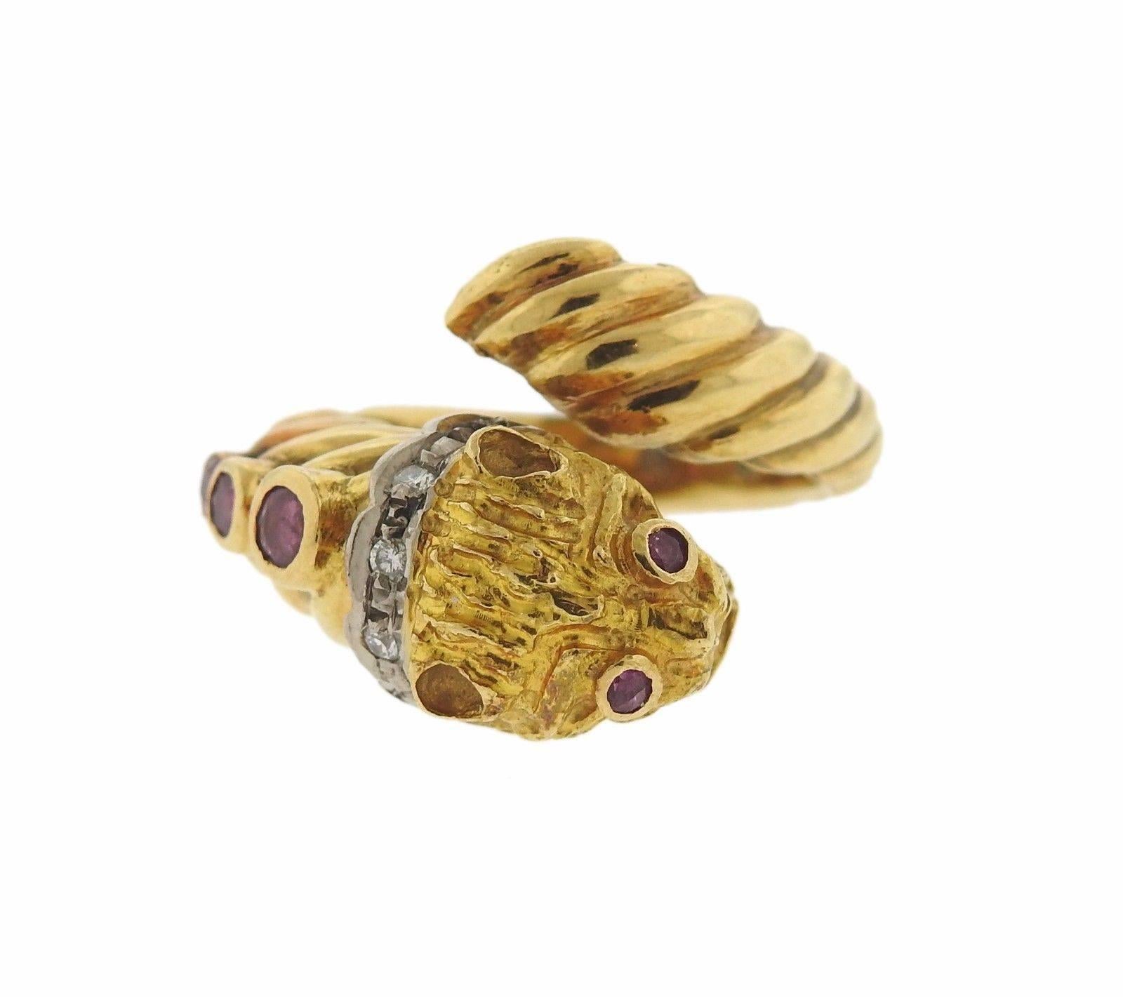 An 18k yellow gold ring set with rubies and approximately 0.05ctw of H/SI diamonds.  The ring is a size 6.75, ring top measures approx. 17mm wide.  The weight of the ring is 9.7 grams. Marked: Maker's mark, A21, 750, Greece.