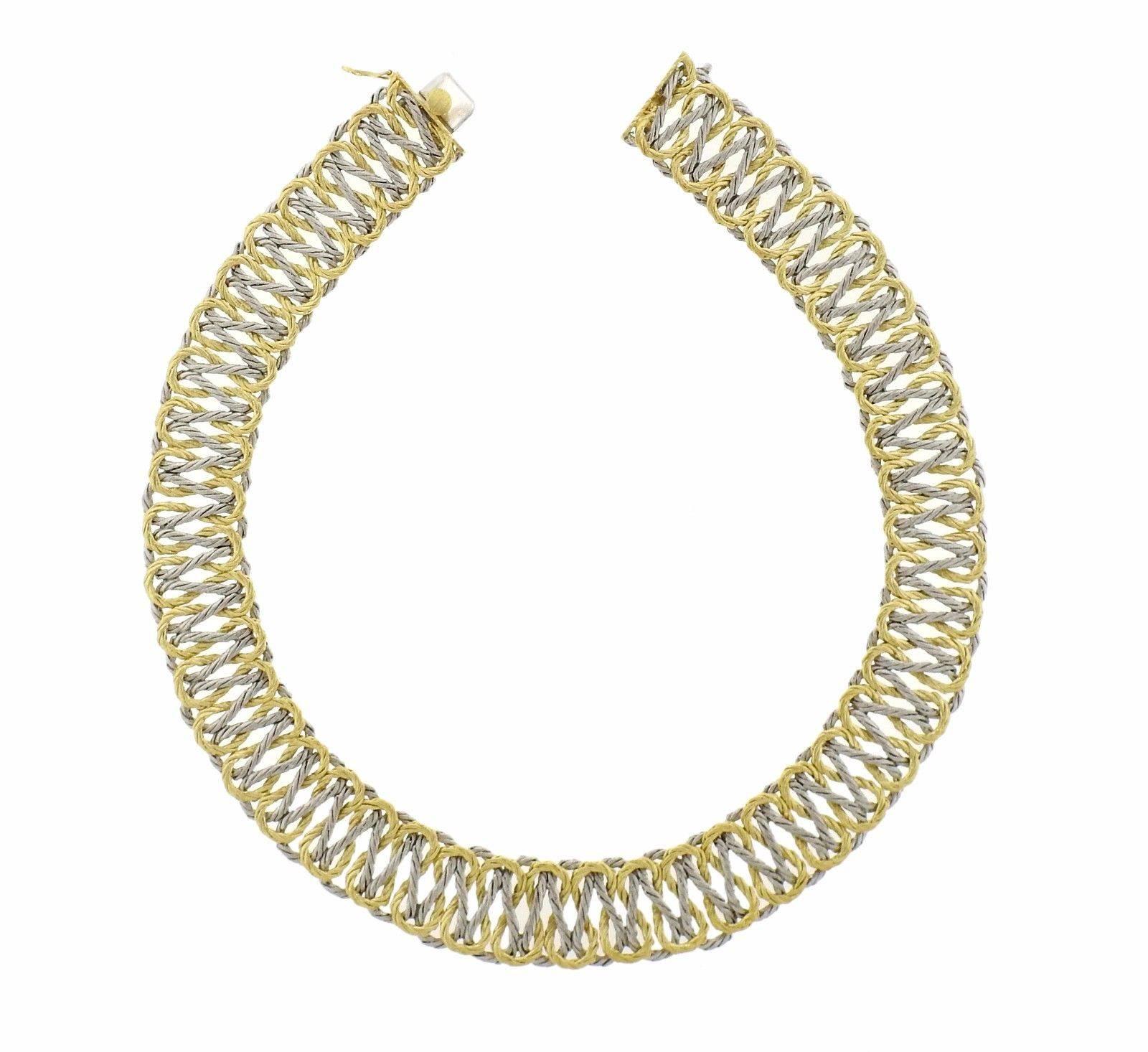 An 18k yellow and white gold necklace in a woven pattern.  The necklace is 15