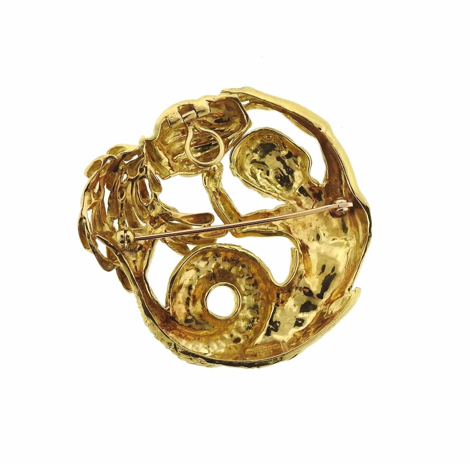 An 18k gold brooch depicting the Aquarius zodiac sign.  The brooch measures 53mm x 51mm and weighs 48.2 grams.  Marked: David Webb, 18k.