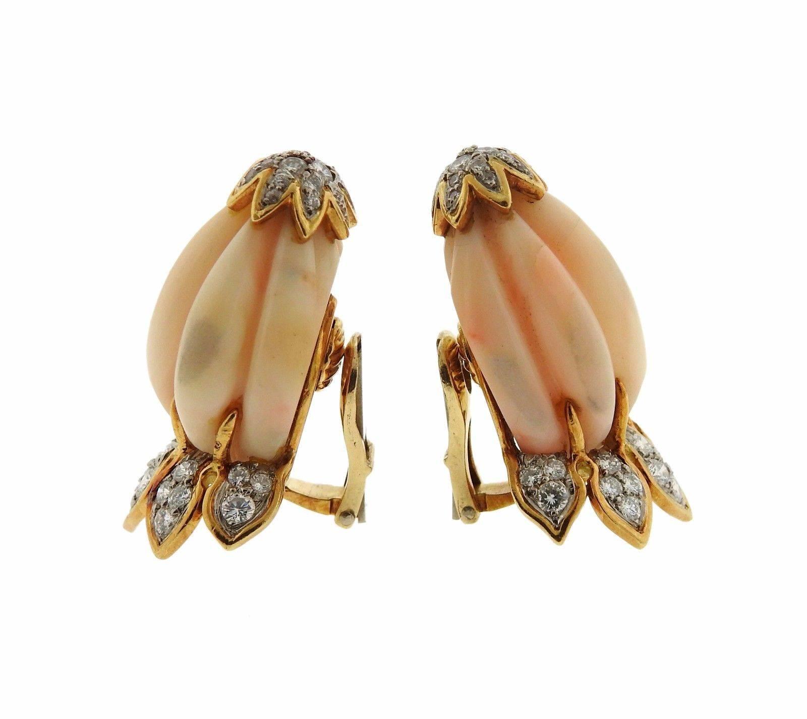 A pair of 18k yellow gold earrings set with carved coral and approximately 2 carats of G-H/VS diamonds.  The earrings measure 36mm x 23mm and weigh 34.2 grams.