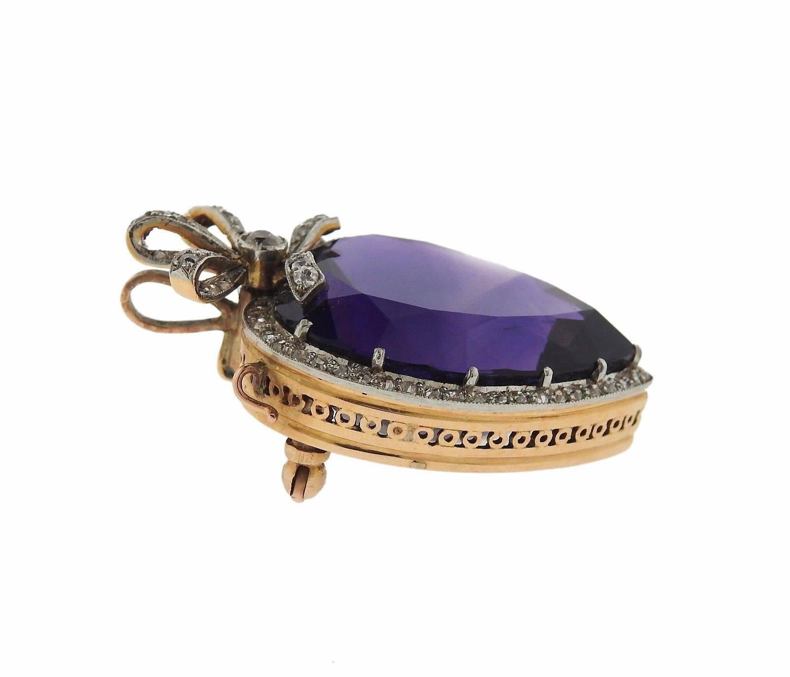 A 15k gold brooch pendant set with and amethyst and approximately 0.70ctw of H/VS-SI diamonds. The pendant measures 40mm x 26mm and weighs 17.7 grams.  Tested 15k. Retailed by S.J. Phillips London 