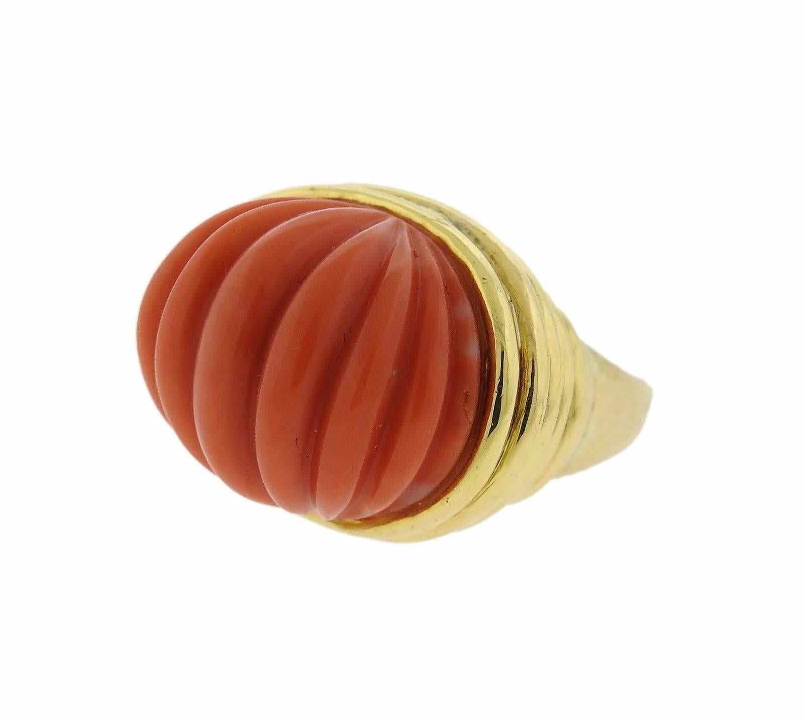 An 18k yellow gold ring set with carved coral.  The ring is a size 7 and weighs 24.9 grams.  The ring top is 20mm x 27mm and sits 17mm from the finger.  Marked: David Webb, 18k.