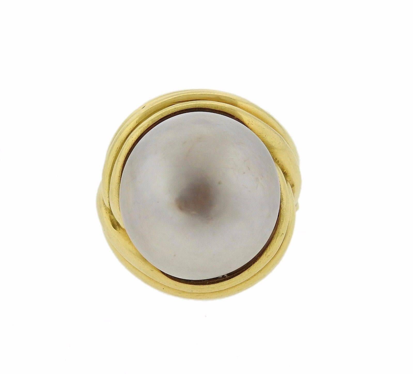An 18k yellow gold ring set with a 19mm mabe pearl.  The ring is a size 8 weighs 23.3 grams.  The ring top is 25mm wide and sits 20mm from the top of the finger.  Marked: A.Clunn, 18k.