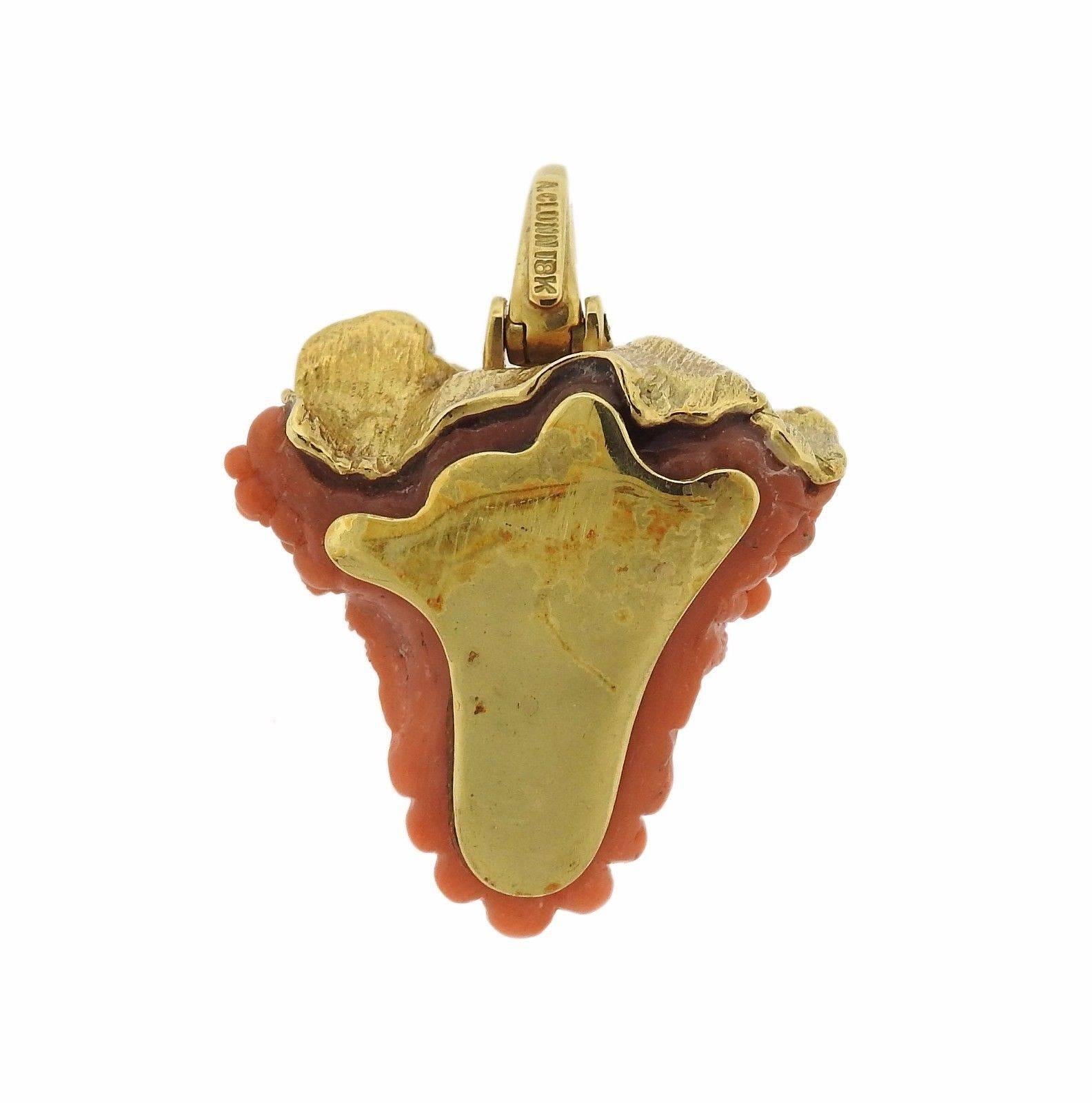 An 18k yellow gold pendant set with carved coral and approximately 0.06ctw of H/VS diamonds.  Measures 30mm X 43mm including bale. The weight of the piece is 22.1 grams.  Marked: A. Clunn, 18k.