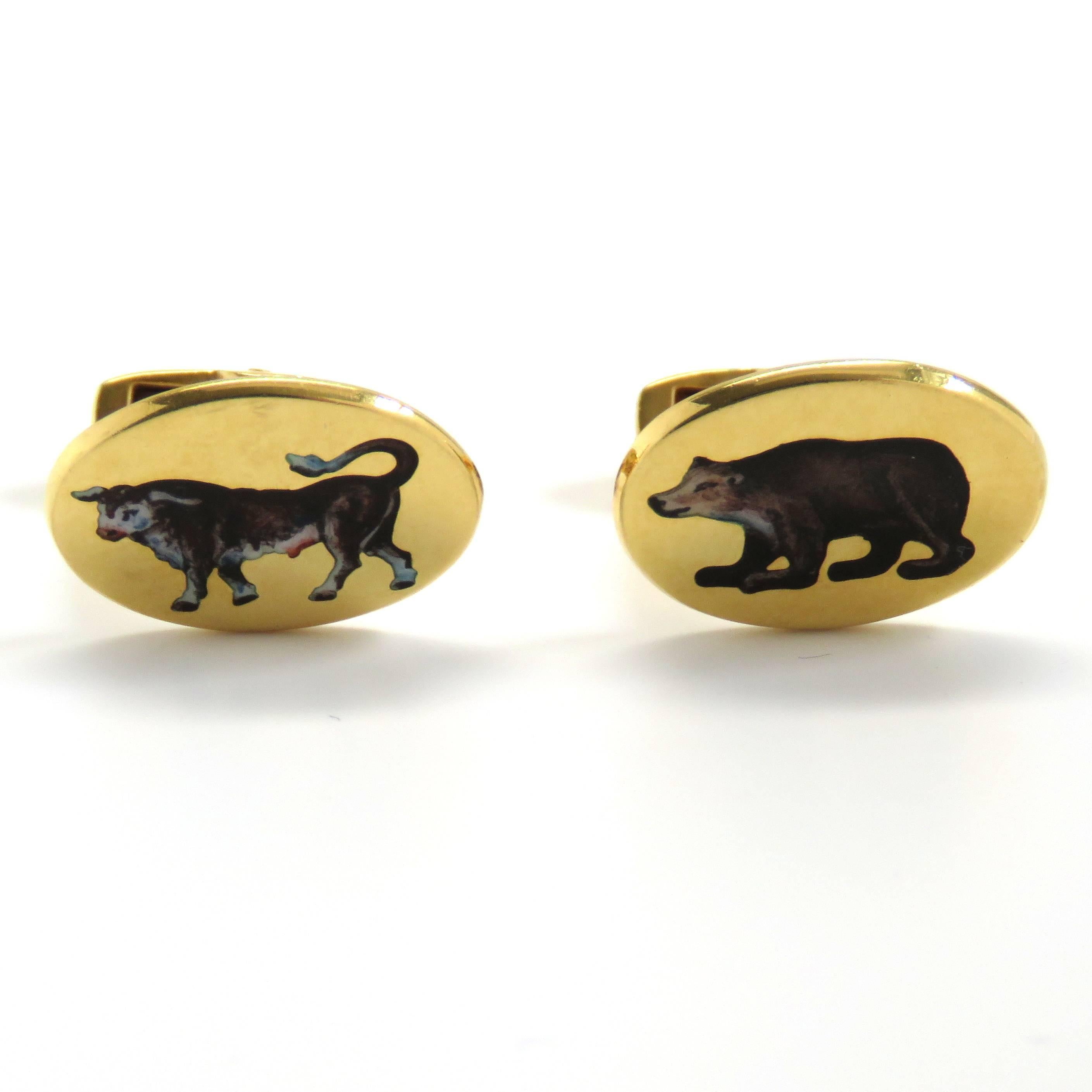 A pair of 18k yellow gold cufflinks depicting a bull and bear, representing the financial markets.  The cufflinks measure 18mm x 14mm and weigh 15.2 grams.  Marked: D&F, England, English Gold Marks.