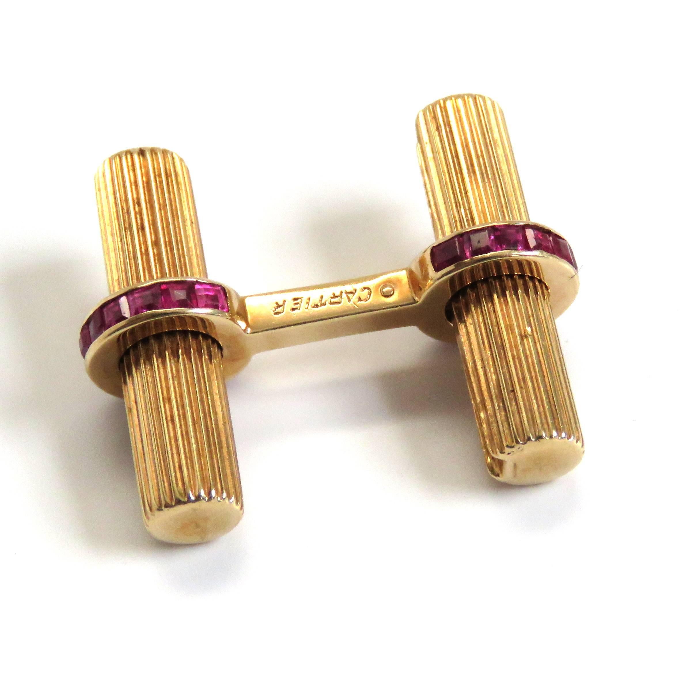 A pair of 14k yellow gold cufflinks set with rubies.  Crafted by Cartier, the cufflinks measure 22.7mm x 9mm and weigh 11.2 grams.  Marked: Cartier, 14k, (Serial number faded).