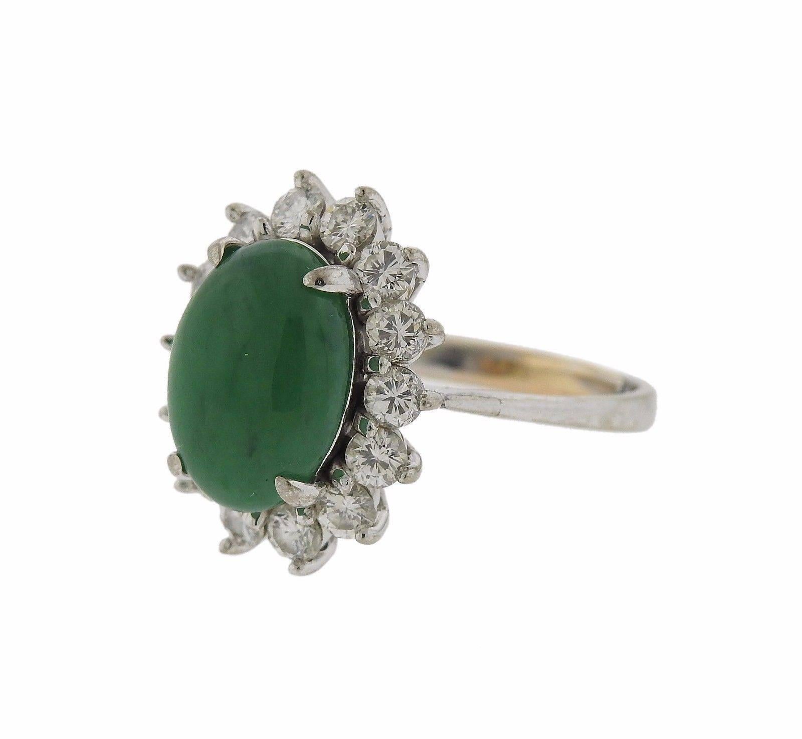 An 18k gold ring set with a natural color jadeite jade (12.81mm x 9.36mm x 5.02mm) and approximately 1 carat of G-H/VS diamonds.  The ring is a size 5 and the ring top measures 19mm x 15mm.  The weight of the piece is 6.5 grams.