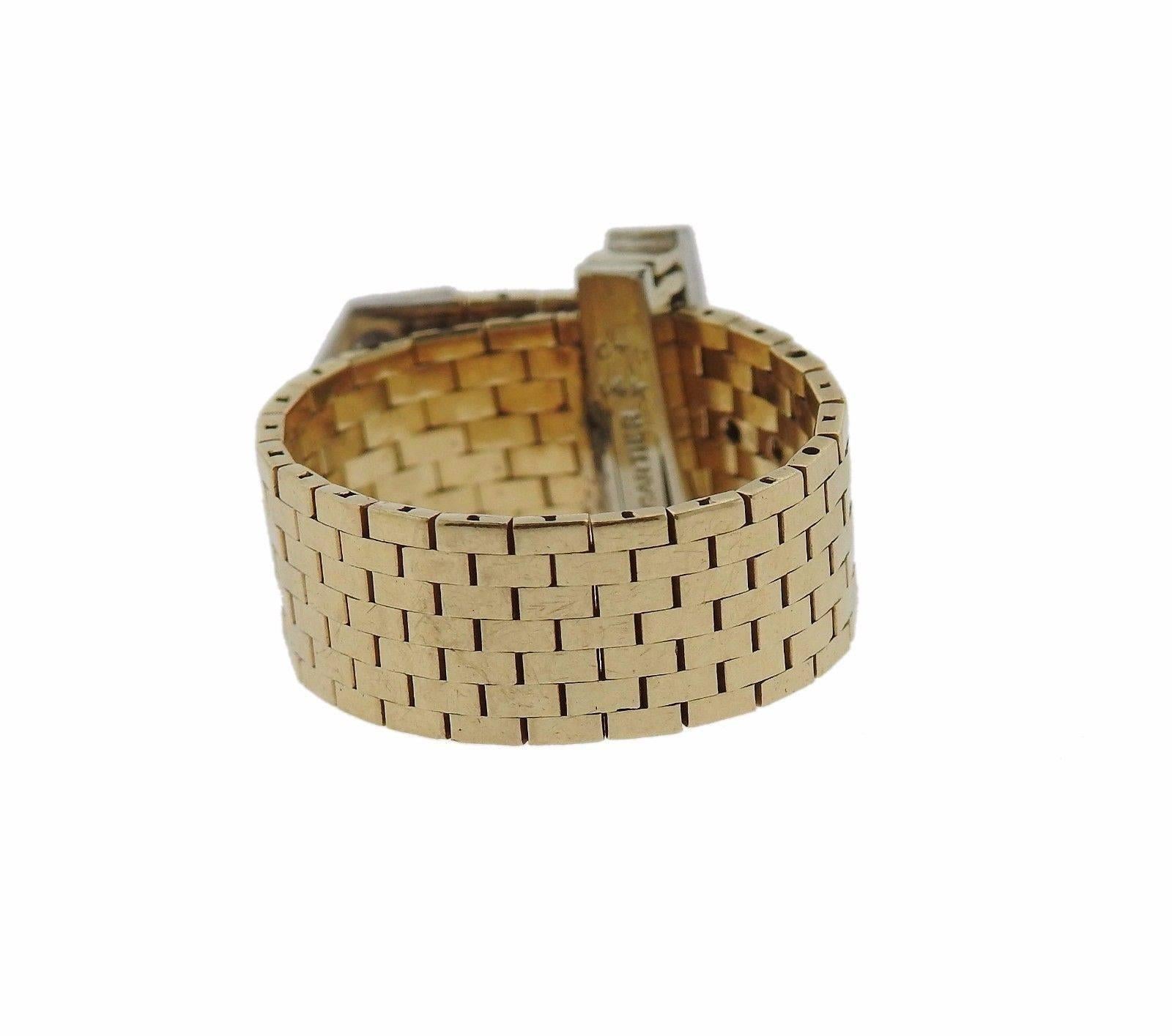 A 14k gold buckle ring crafted by Cartier in the 1940s.  It is set with approximately 0.35ctw of G/VS diamonds.  The ring is adjustable in size from a 4 1/4 to a 9.  The ring is 8.2mm wide and weighs 8 grams.  Marked: Cartier, 14k.