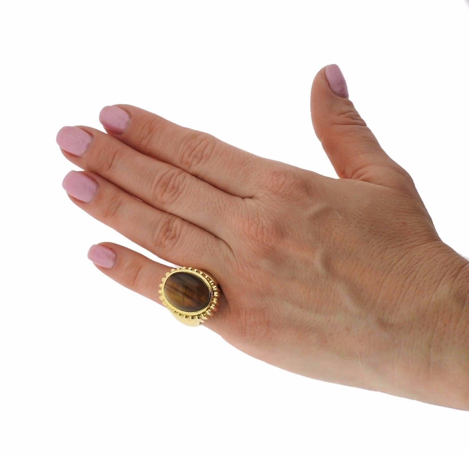 An 18k yellow gold ring set with Tiger's eye.  The ring is a size 6, the top measures 25mm x 20mm.  The weight of the piece is 24.5 grams.  Marked: 18k Webb.