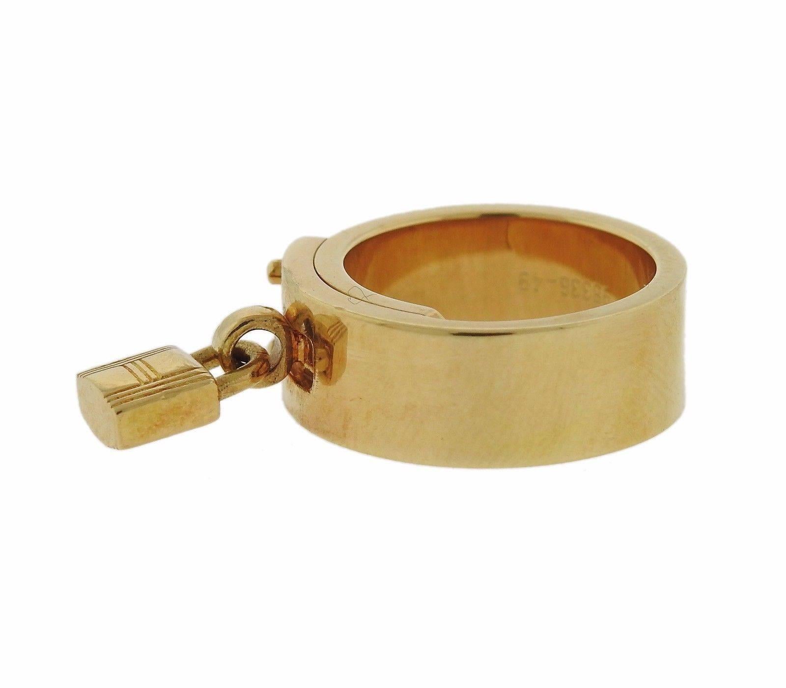 An 18k gold ring by Hermes.  The ring is a size 4 1/2 and the ring is 7.4mm wide.  The  charm measures 9mm x 5.5mm.  The weight of the piece is 15.3 grams.  Marked:	Au750, Hermes, 98336-49.