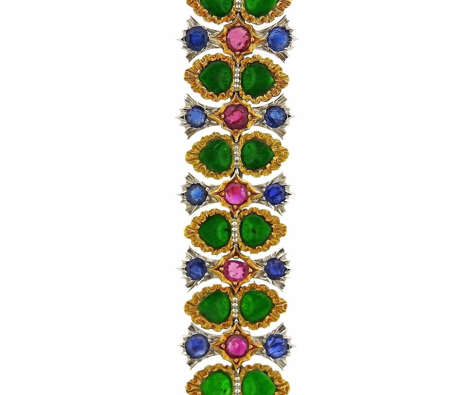 An important 18k gold bracelet set with sapphires, rubies and carved jade.  The bracelet measures 6 7/8