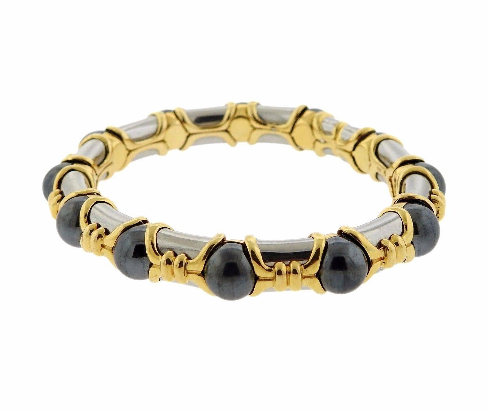 An 18k yellow gold and stainless steel bracelet set with 8.4mm hematite stones.  The bracelet will fit up to a 6 3/4" wrist.  Marked: 1998,  Bvlgari, 750, M, 2337AL.  The weight of the piece is 50.7 grams.