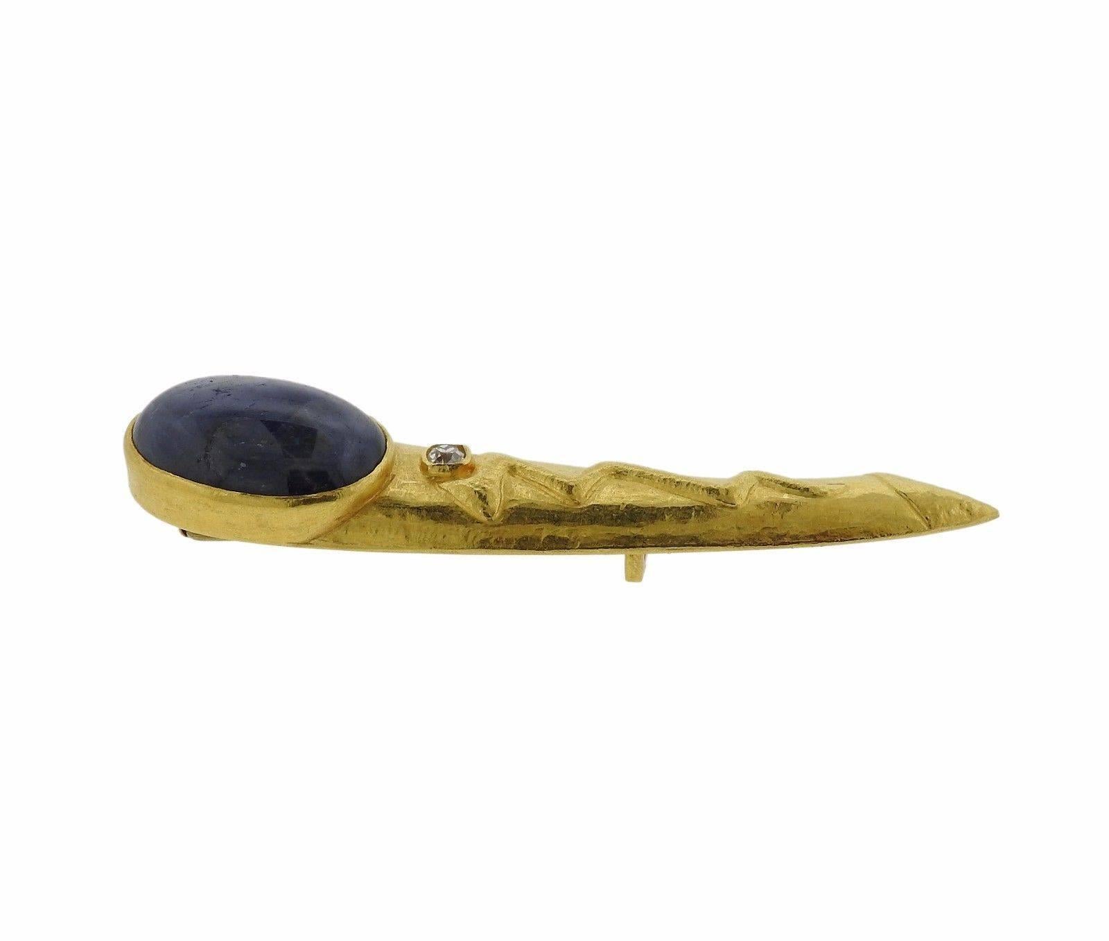 A 22k yellow gold brooch set with a sapphire cabochon (25mm x 18mm) and an old mine cut I/SI diamond weighing approximately 0.25ct.  The brooch measures 84mm x 18mm and weighs 34.4 grams.  Marked: 900, Maker's Hallmark.