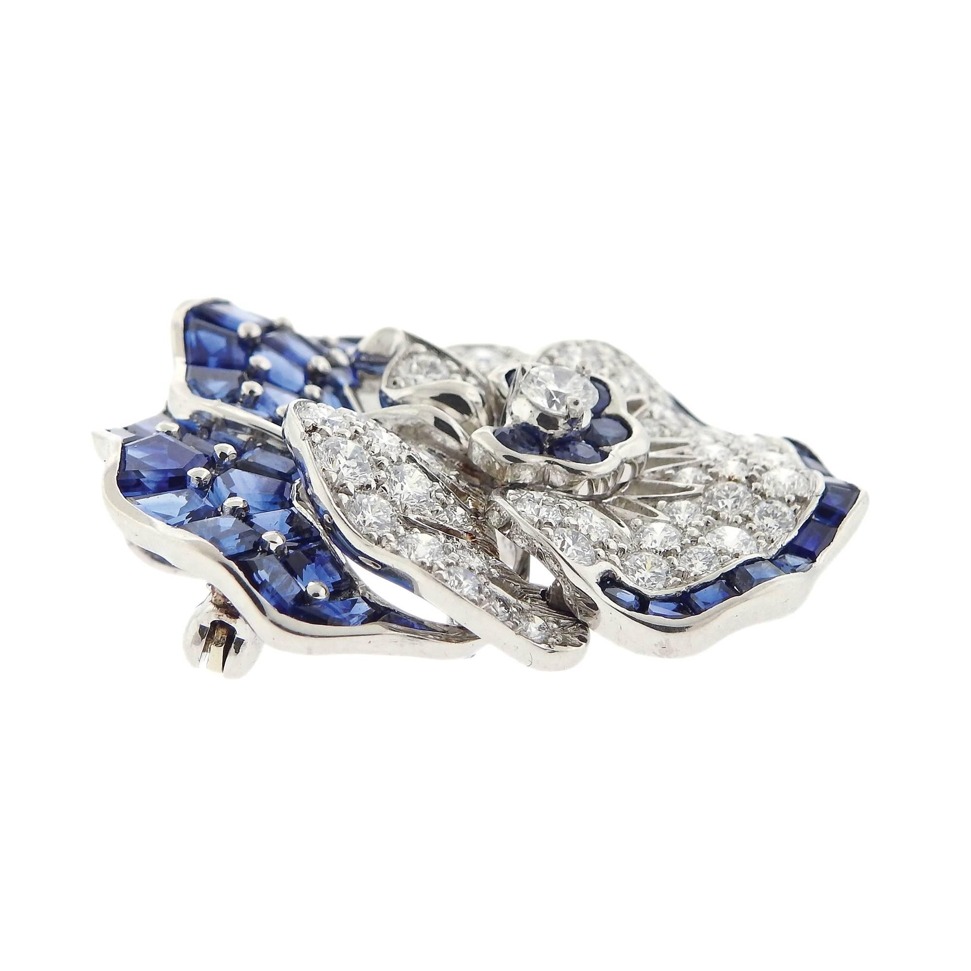 Iconic platinum pansy flower brooch, crafted by Oscar Heyman, decorated with approximately 3.25ctw in diamonds and 9.00ctw in blue sapphires. Brooch measures 35mm x 33mm. Marked: pt900, 10% irid, Maker's mark, 200174. Weigh of the piece - 23.8 grams.
