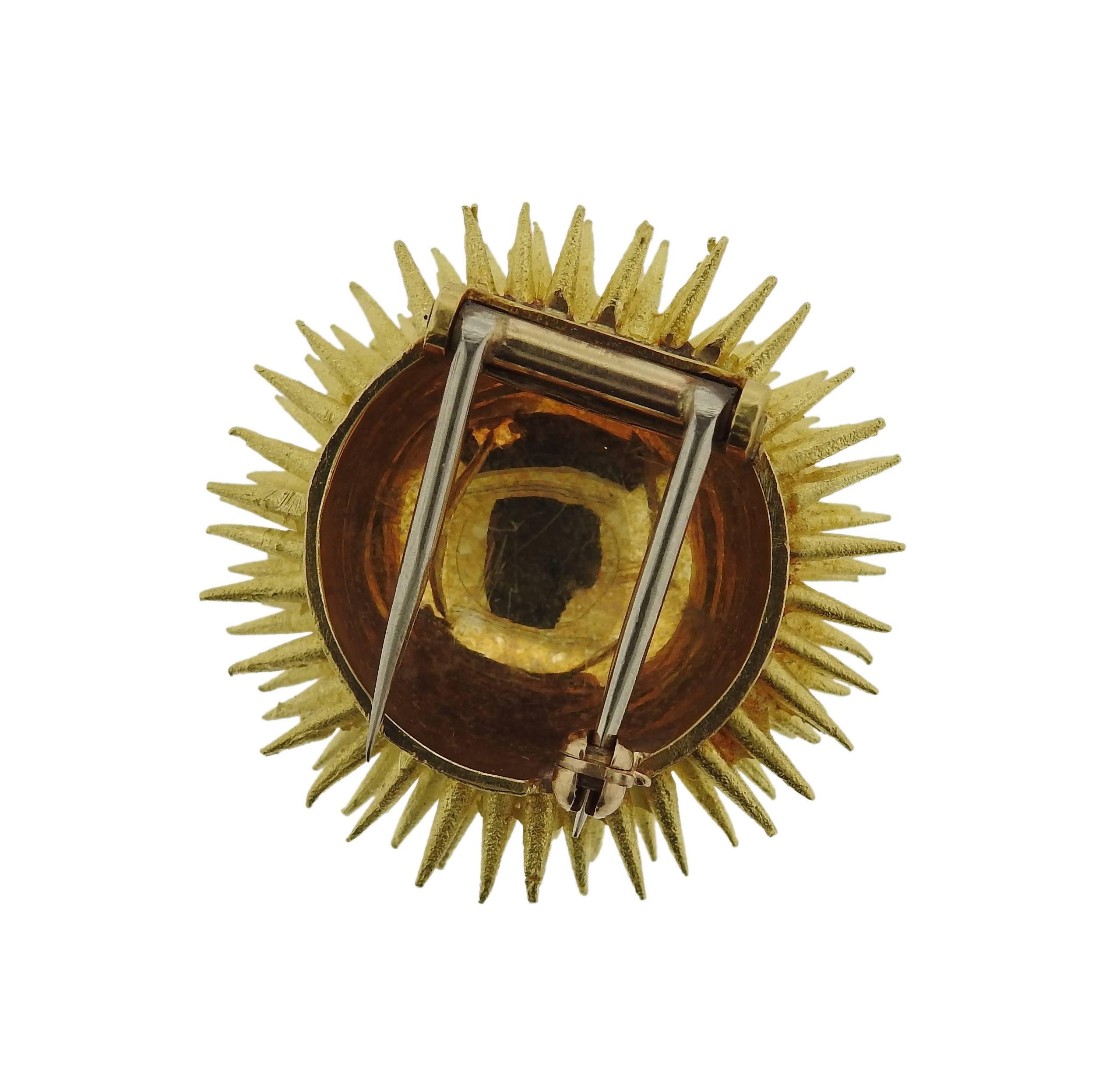An 18k yellow gold sea urchin brooch, crafted by Tiffany & Co, decorated with a diamond and rubies. Brooch measures 26mm in diameter and weighs 17.1 grams. Marked Tiffany & Co and 18k. 