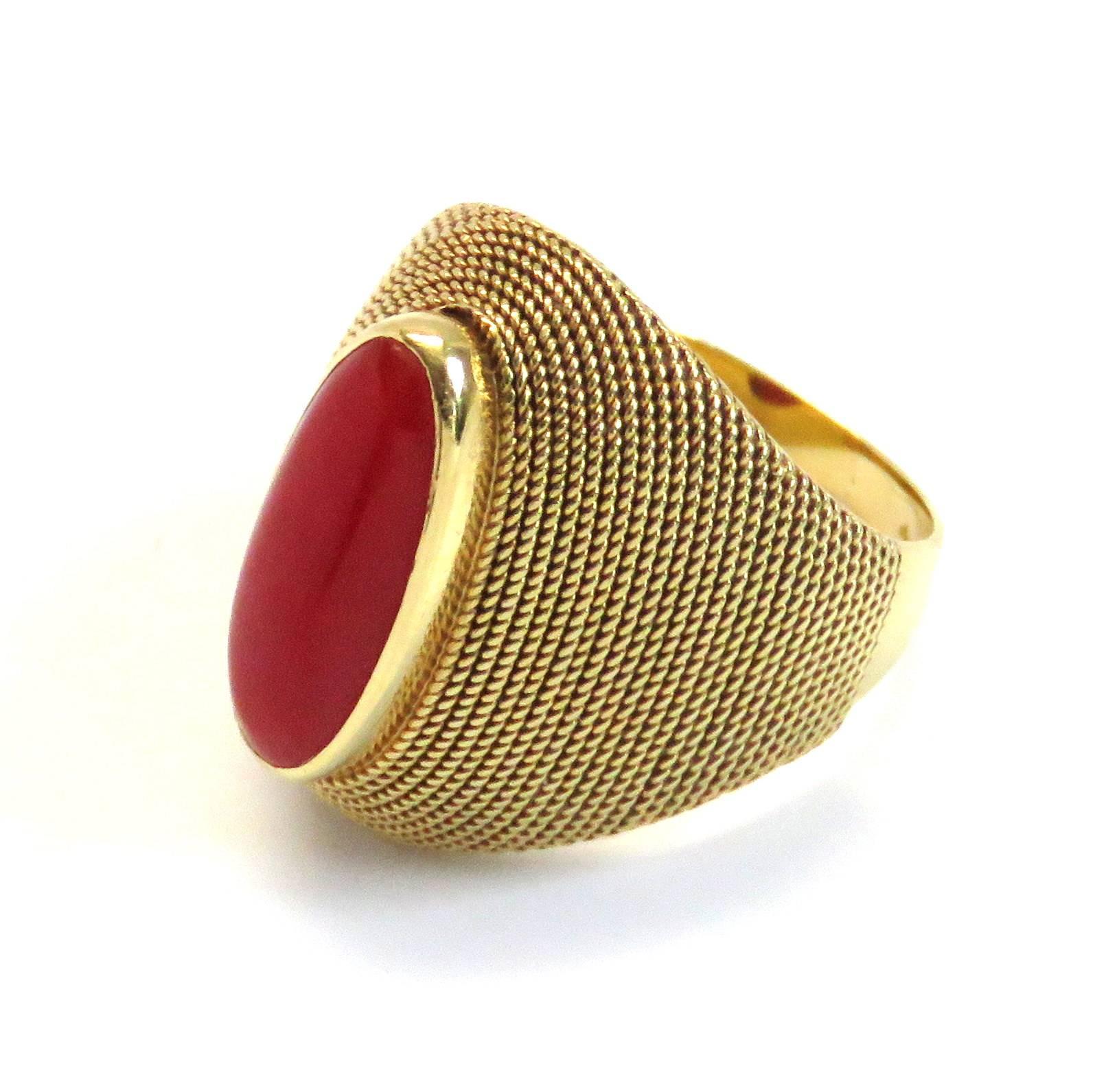 An 18k yellow gold ring set with coral (14mm x 6mm).  The ring is a size 5 and measures 19.5mm at the widest point.  The weight of the ring is 6.8 grams.  Marked: 18k, Italy.