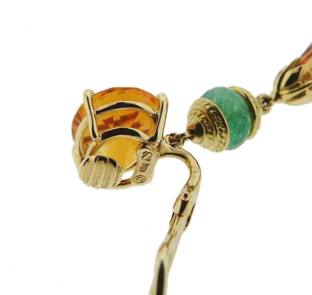 A pair of 18k yellow gold earrings set with emeralds and citrines.  The earrings measure 53mm x 14mm and weigh 19.4 grams.  Marked: Shell signature mark, 750. The pair currently retails for $7,680.