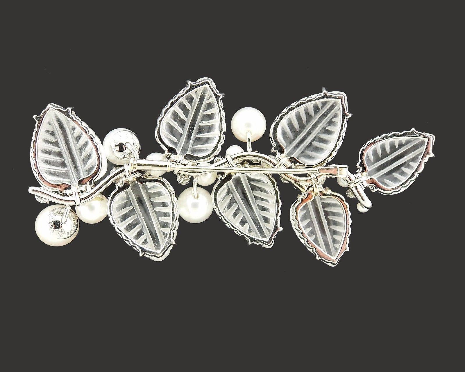 An 18k white gold brooch set with carved crystal leaves, pearls (2.5mm - 9mm) and approximately 0.80ctw of G/VS diamonds.  The brooch measures 85mm x 40mm and weighs 43.2 grams.  Marked: 10902, 750, Shell hallmark, Seaman Schepps.