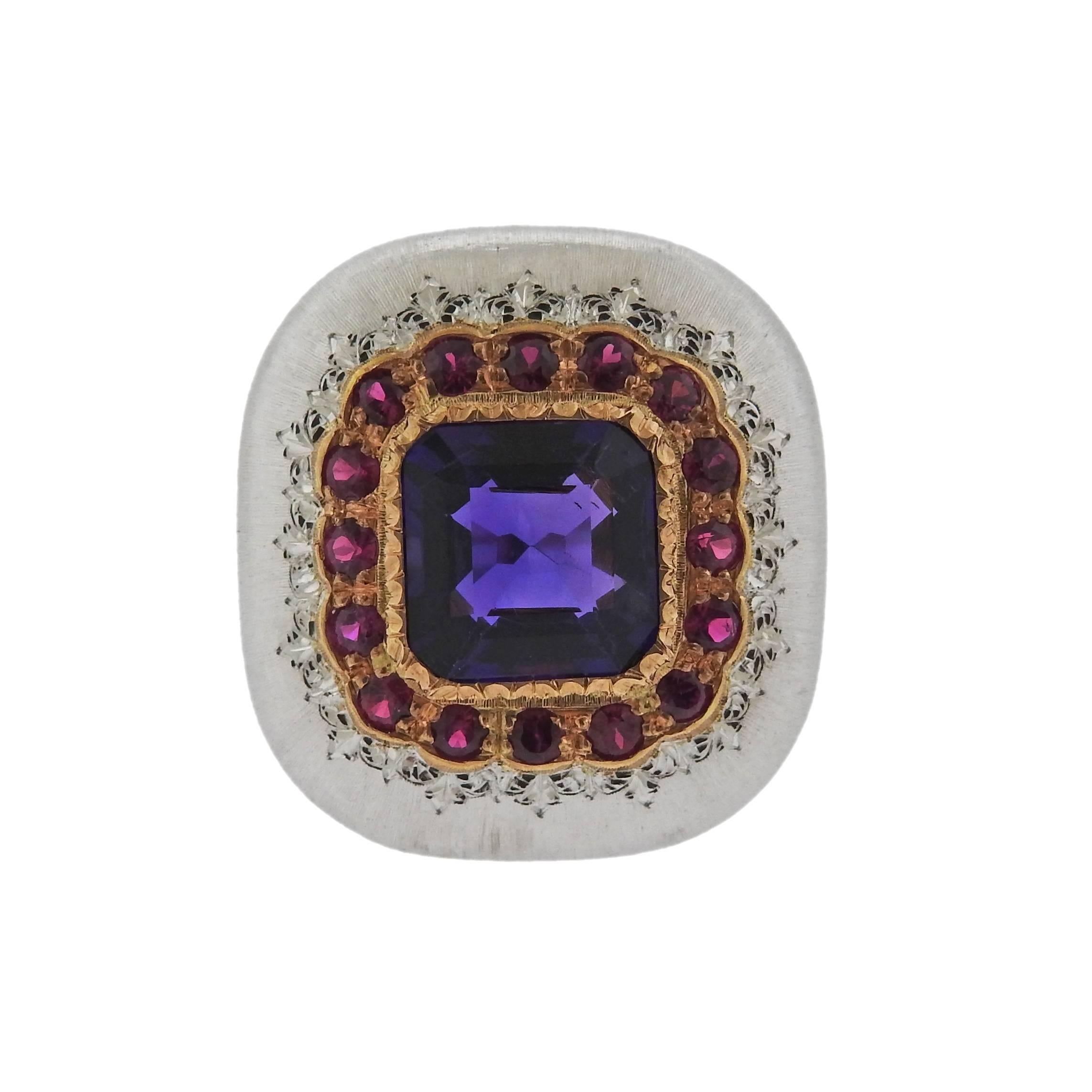 18k gold ring crafted by Buccellati featuring an amethyst center surrounded by rubies. Ring is a size 5.75, ring top is 21mm x 20mm. Marked S6166, Ialy, 18k, Buccellati . Weight is 10.9 grams. Comes with Buccellati paperwork and retails for $20,400.