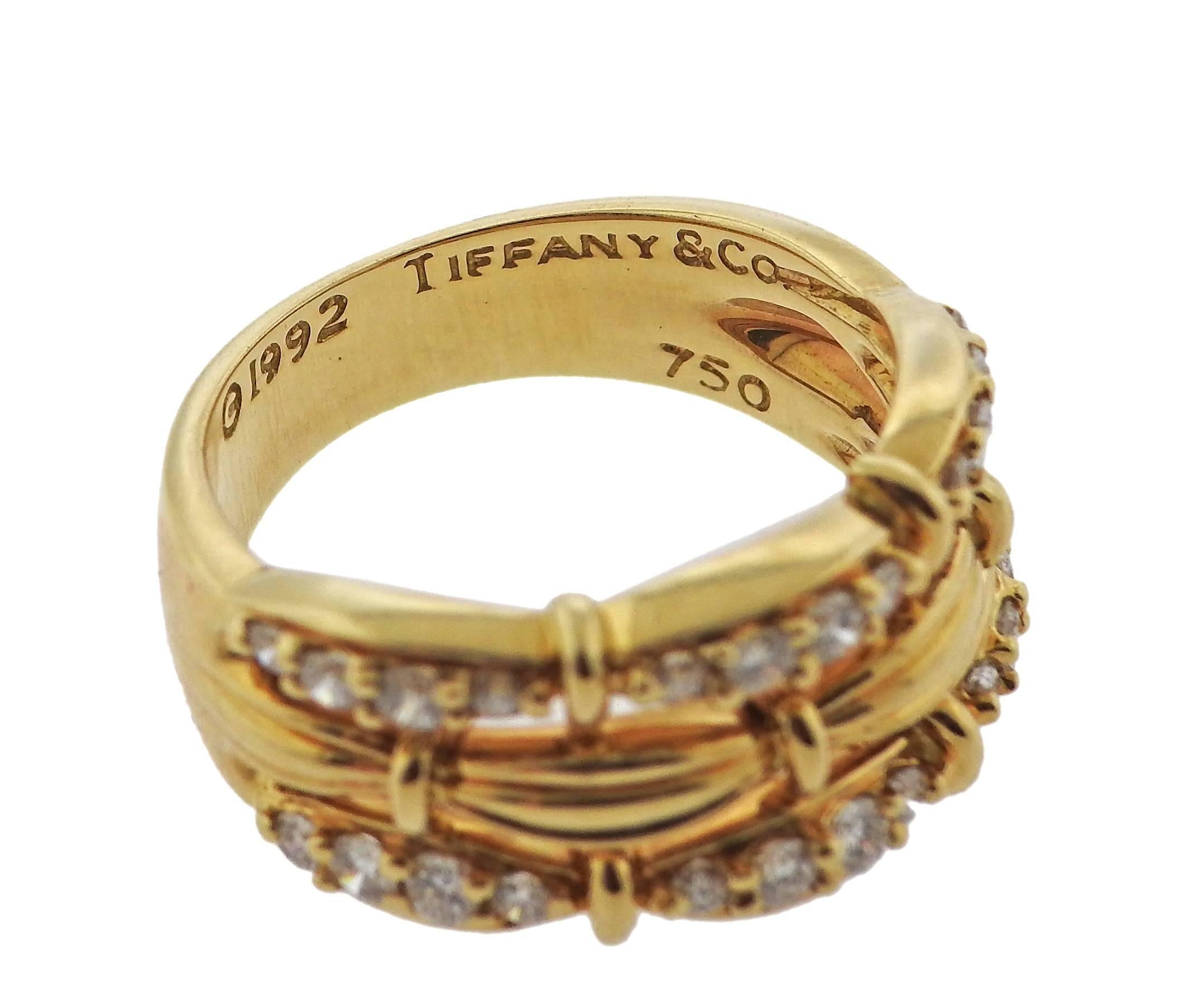 18k yellow gold ring, crafted by Tiffany & Co in circa 1992, set with approximately 0.60ctw in diamonds.  Ring size 7 1/4, ring top is 10.5mm wide and weighs 9.1 grams. Marked: Tiffany & Co, 1992, 750