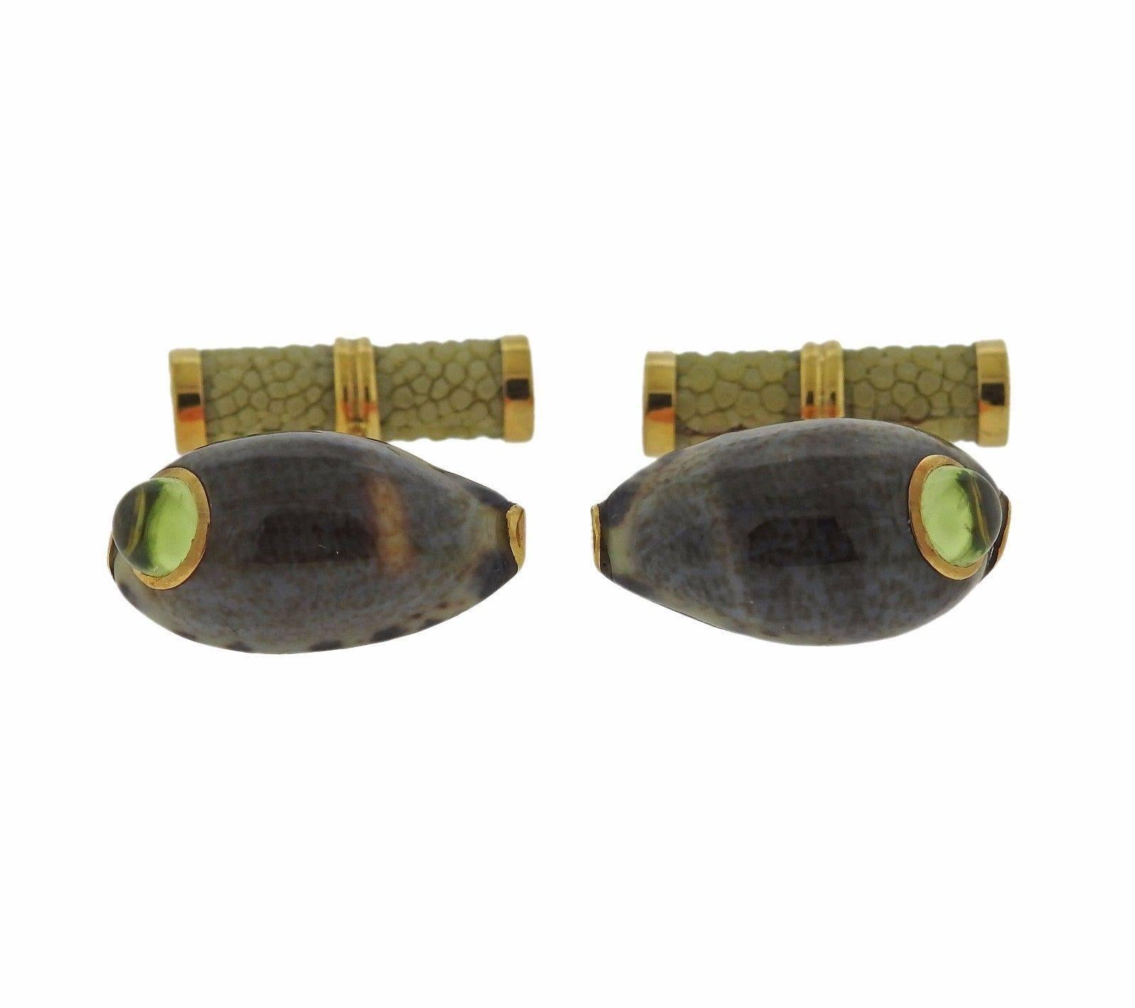 A pair of 18k yellow gold shell cufflinks set with peridot cabochons.  The shells measure 21mm x 12mm.  The weight of the set is 10.3 grams.  Marked: Trianon, 750, Trianon mark.