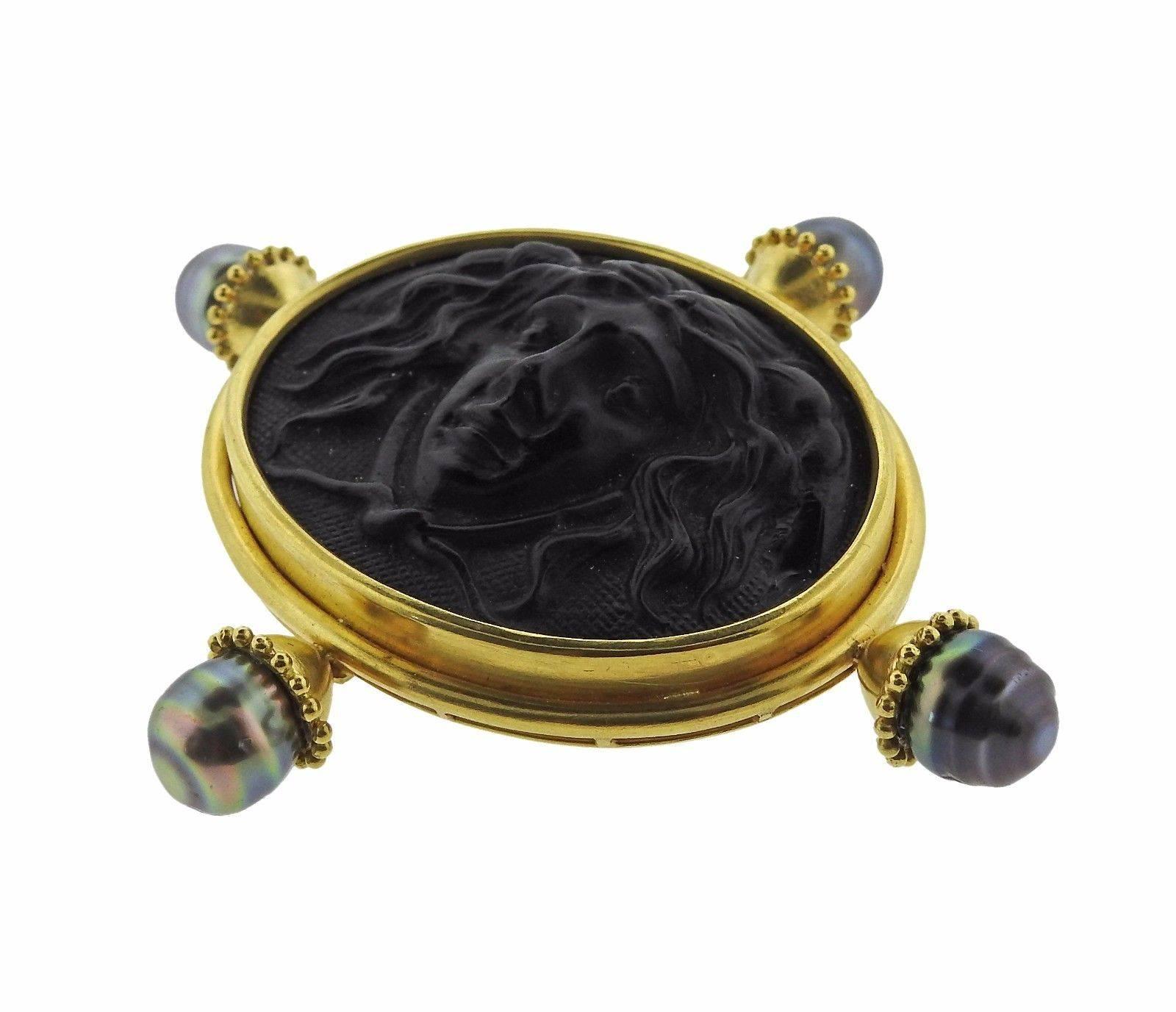 An 18k yellow gold brooch set with black intaglio and 10.5mm pearls.  The brooch measures 87mm x 78mm and weighs 70.5 grams.  Marked: 18k, Locke mark.