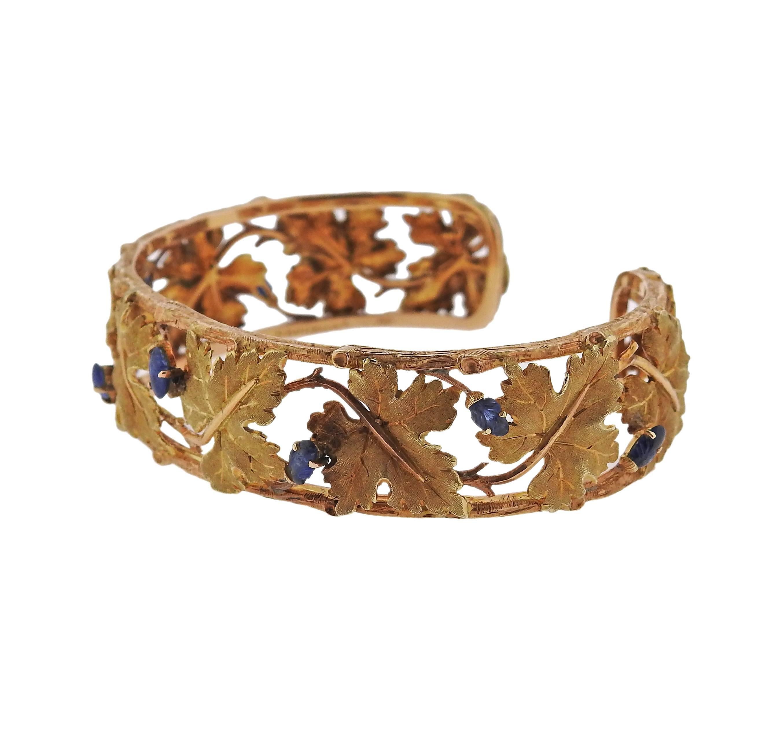 An 18k gold leaf motif bracelet crafted by Buccellati, featuring carved sapphire. Bracelet measures 17.5mm wide. Will fit up to 6.75