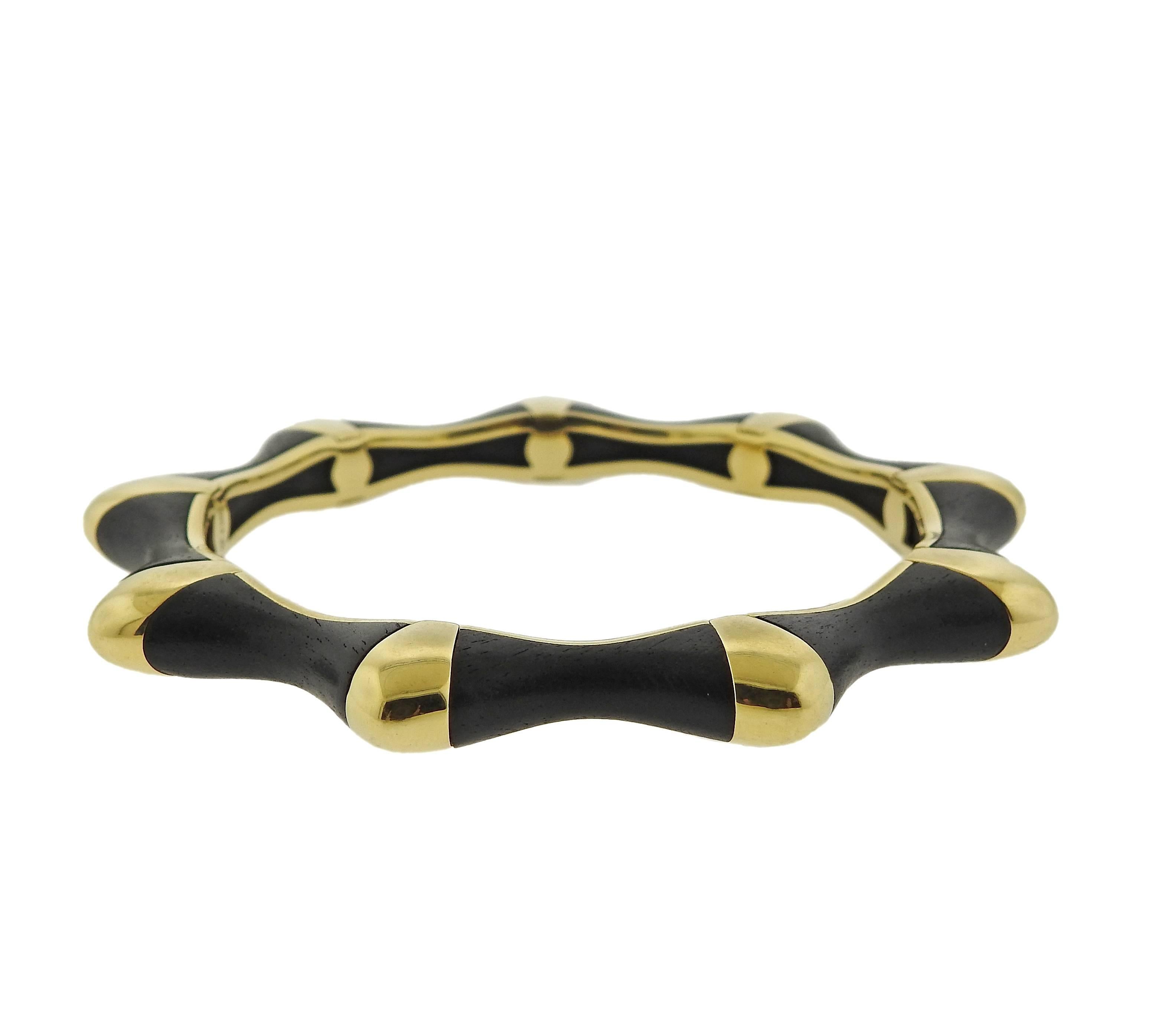 An 18k gold bangle bracelet, decorated with ebony. Crafted by David Webb, Inner diameter of the bangle is 2 7/16
