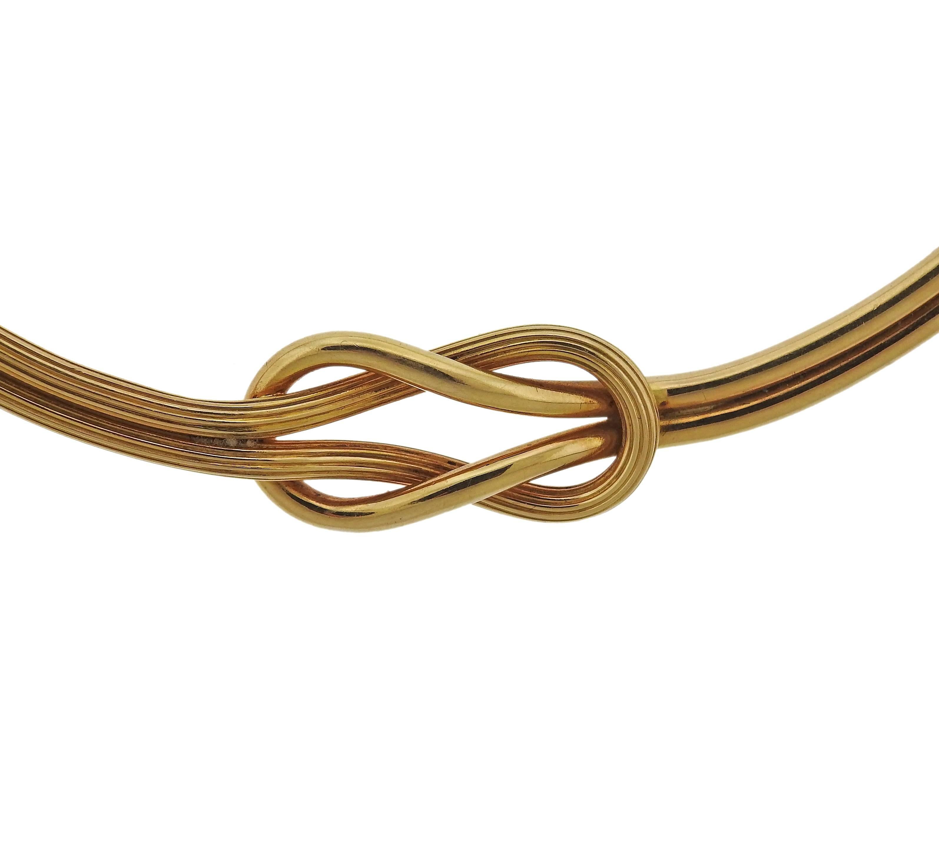 An 18k yellow gold necklace, crafted by Ilias Lalaounis, featuring tied knot design. Necklace's inner circumference is 16" , knot measures 33mm x 16mm.  Weight - 32.2 grams. Marked: 12, 750, Maker's mark, Greece 