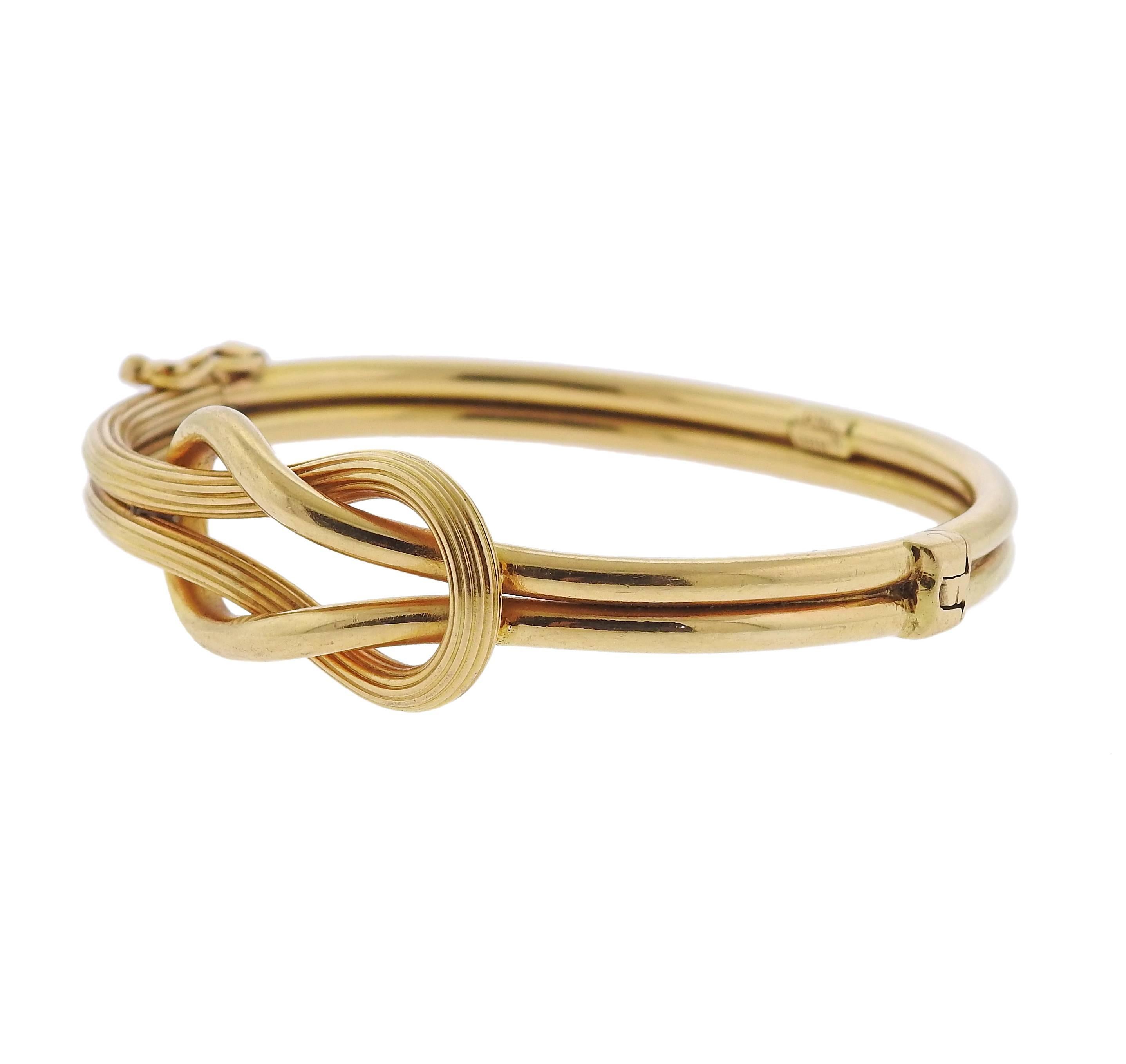 An 18k yellow gold bangle bracelet, crafted by Ilias Lalaounis, featuring tied knot design. Bracelet will fit approx. 7 1/2" wrist, knot is 16mm x 31mm. Marked: Greece, 750, Maker's mark . Weight - 19.2 grams 