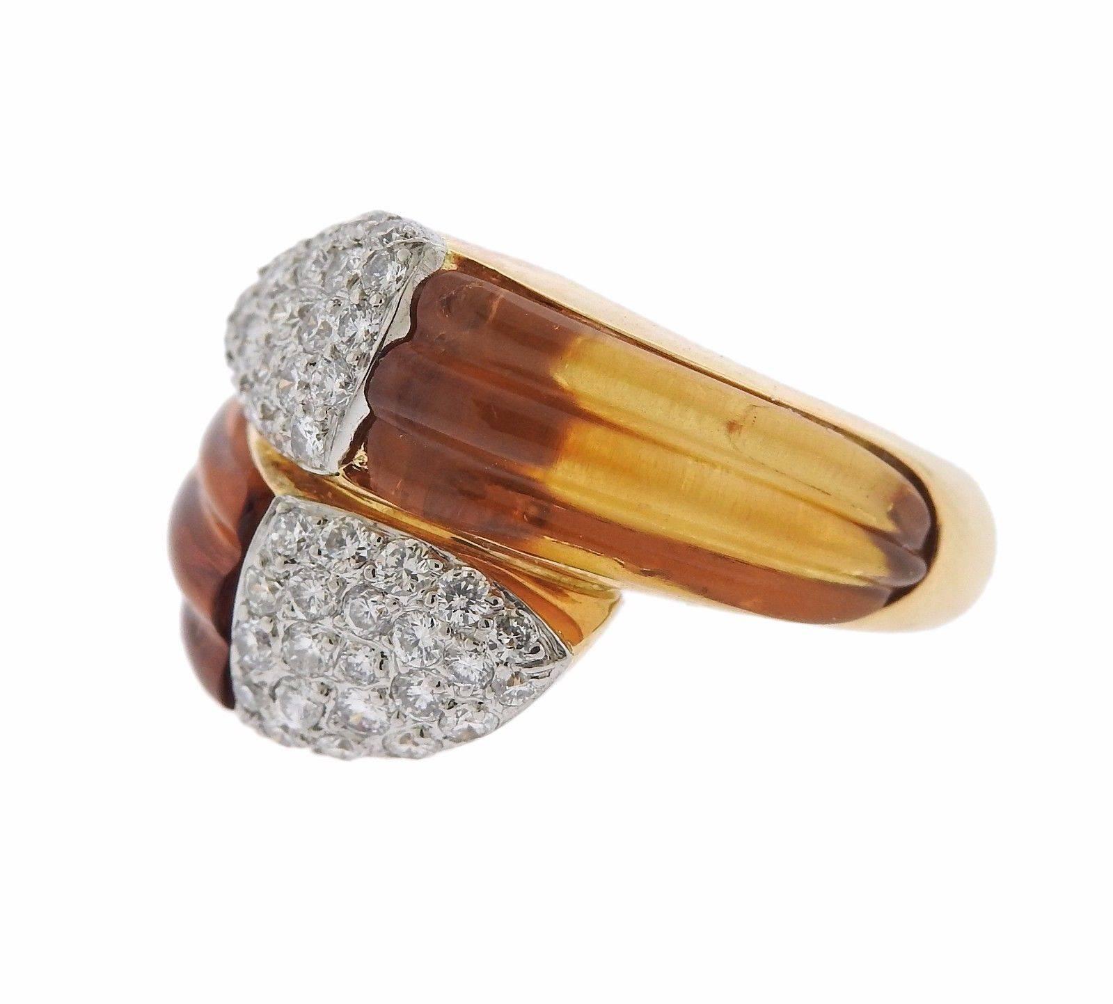 An 18k gold ring set with carved citrine 1.10ctw of GH/VS diamonds.  The ring is a size 6 and 16mm wide. The weight of the piece is 10.6 grams.  Marked: Gold hallmarks, 1.10.