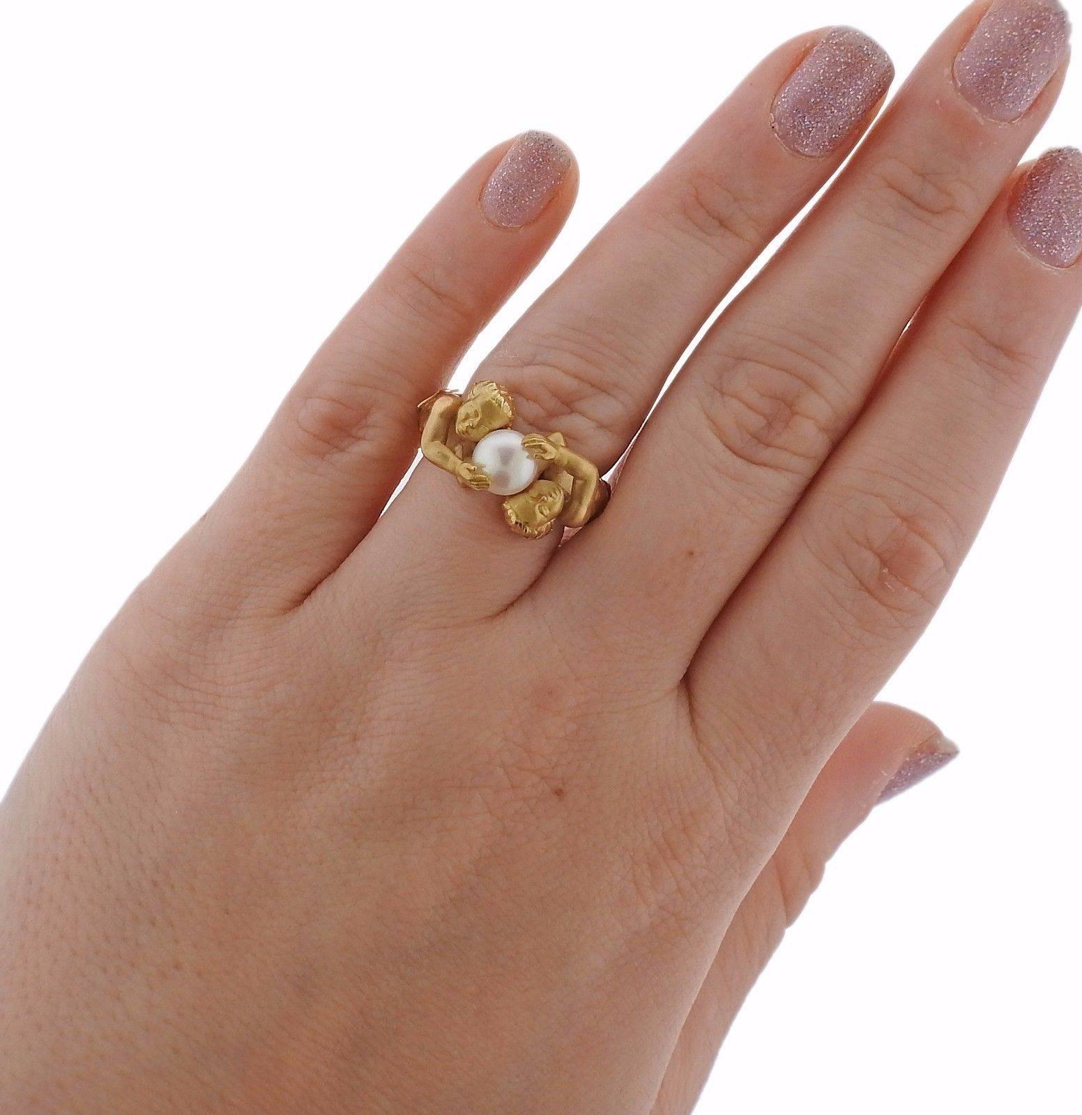 An 18k yellow gold ring set with a 7mm pearl.  The ring is a size 7 and the ring top is 11mm x 20mm. The weight of the ring is 14 grams.  Marked: Carrera mark, 750, 101416.