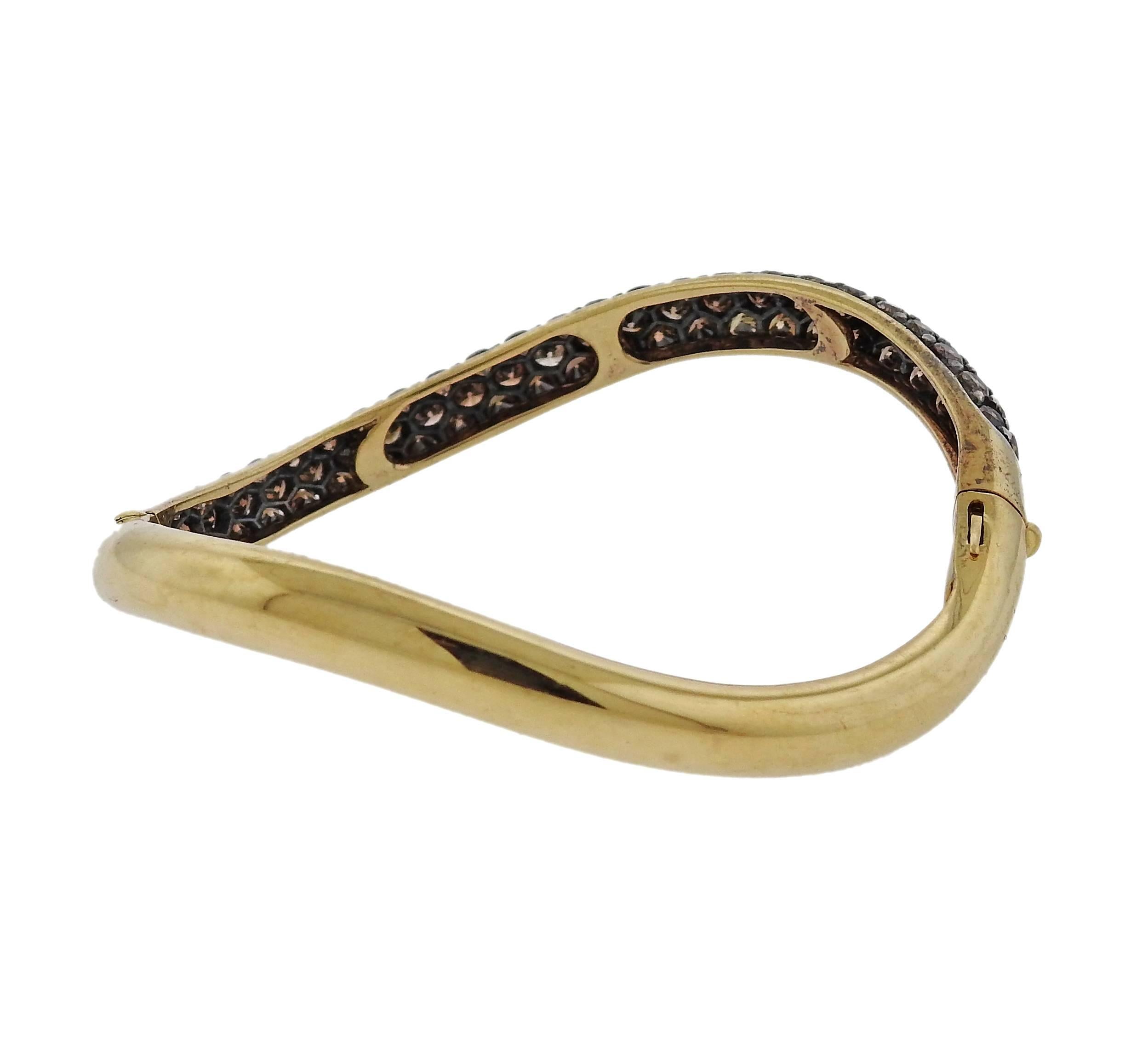 An 18k yellow gold wave bracelet, decorated with approx. 6.00ctw in fancy diamonds. Crafted by Gioia. Will fit approximately 7" wrist. 6.5mm wide. Marked: 750, Gioia. Weight - 28.4 grams